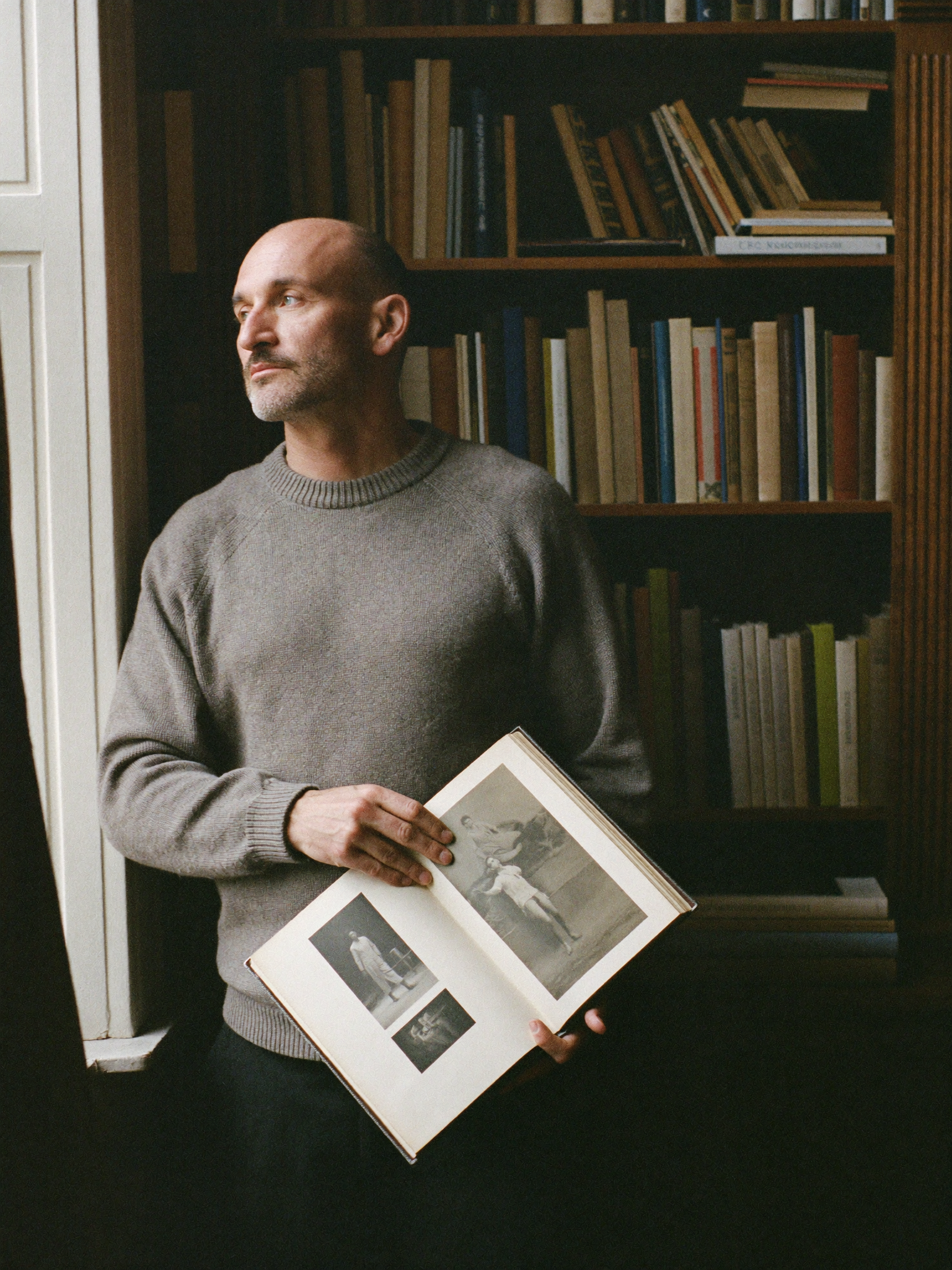 Man in a study holding a handmade photo album