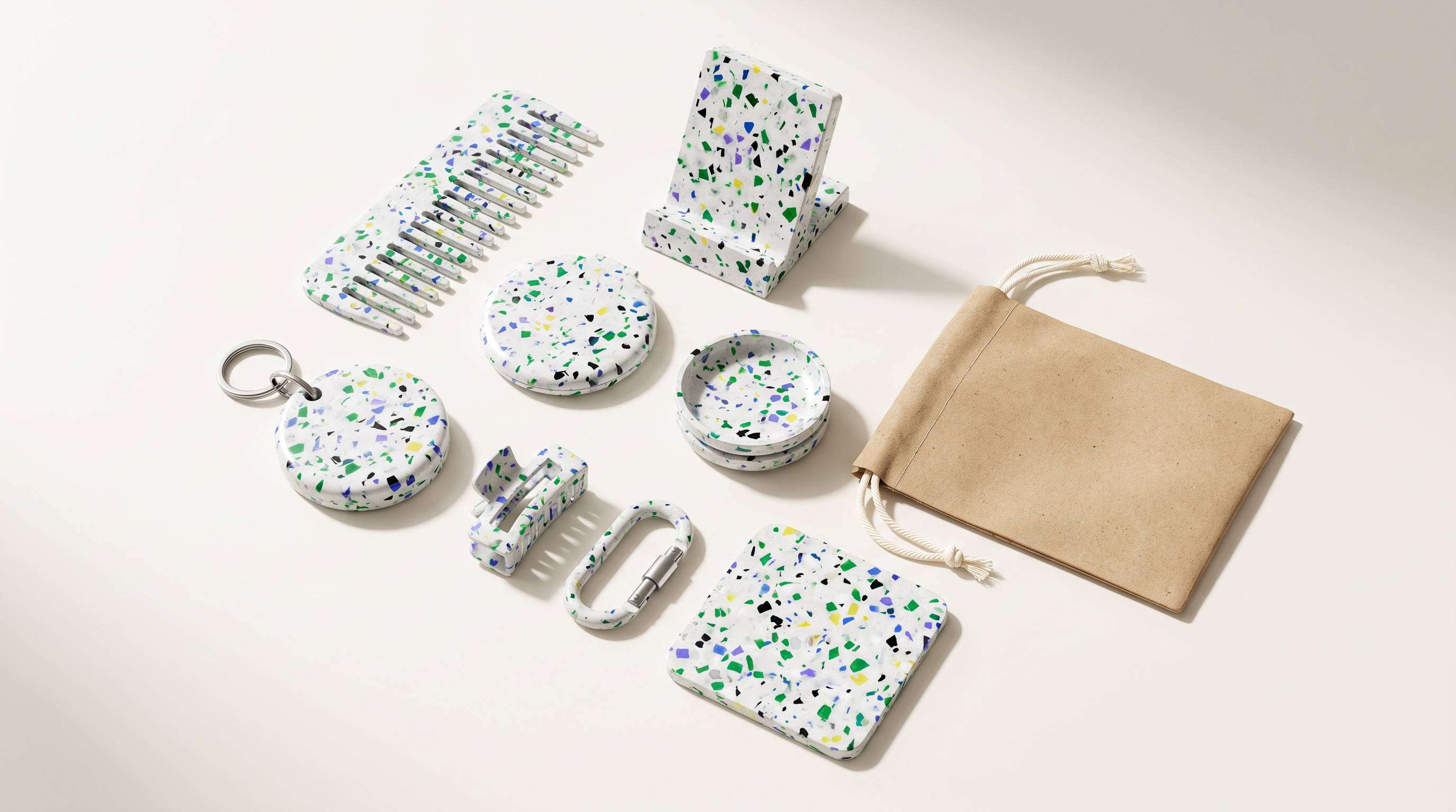 Gift objects machined from bright speckled recycled terrazzo on a pale surface.