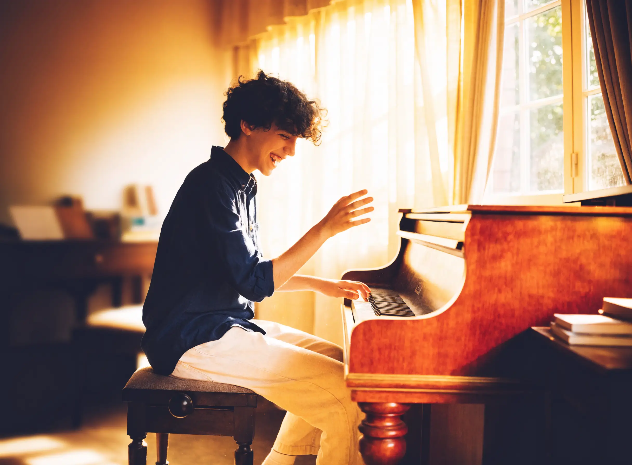 A student smiling while playing the piano