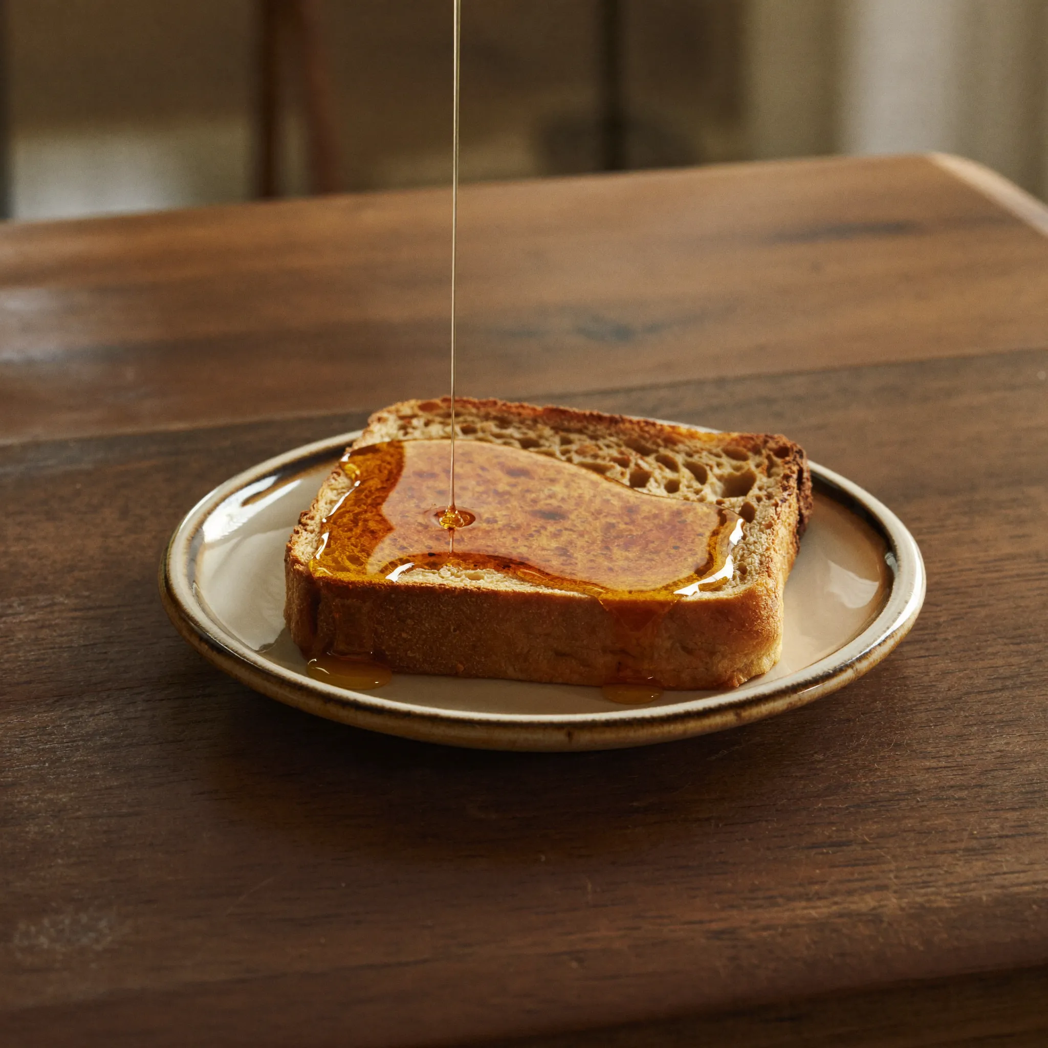 Honey drizzled over sourdough toast in morning light