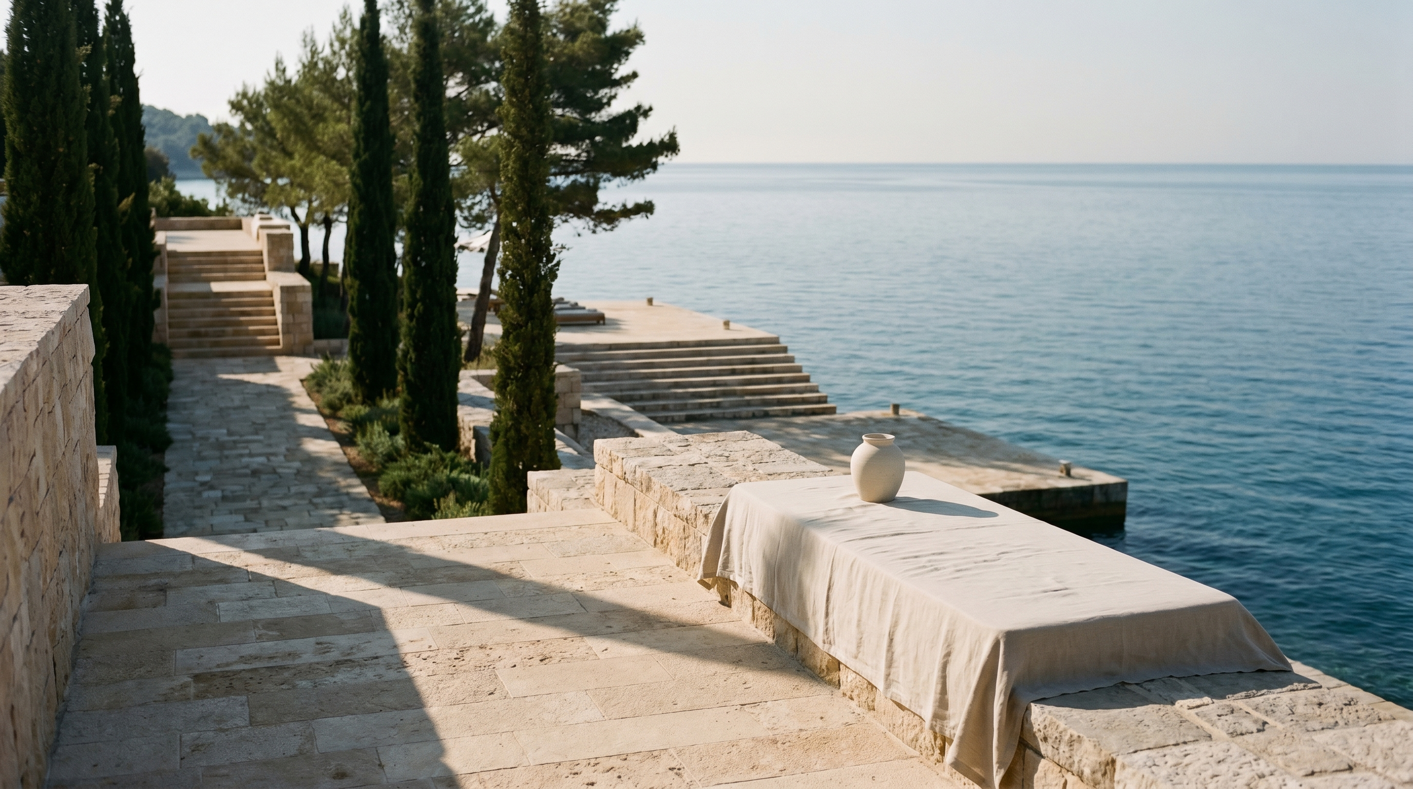 The Adriatic coast at the AUTEUR resort, warm light over limestone and sea.