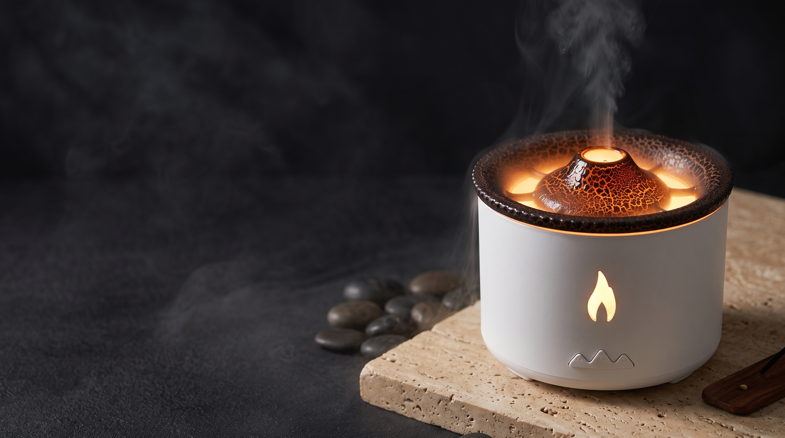 GLÖD volcano diffuser on travertine stone in a dark spa setting with cascading mist
