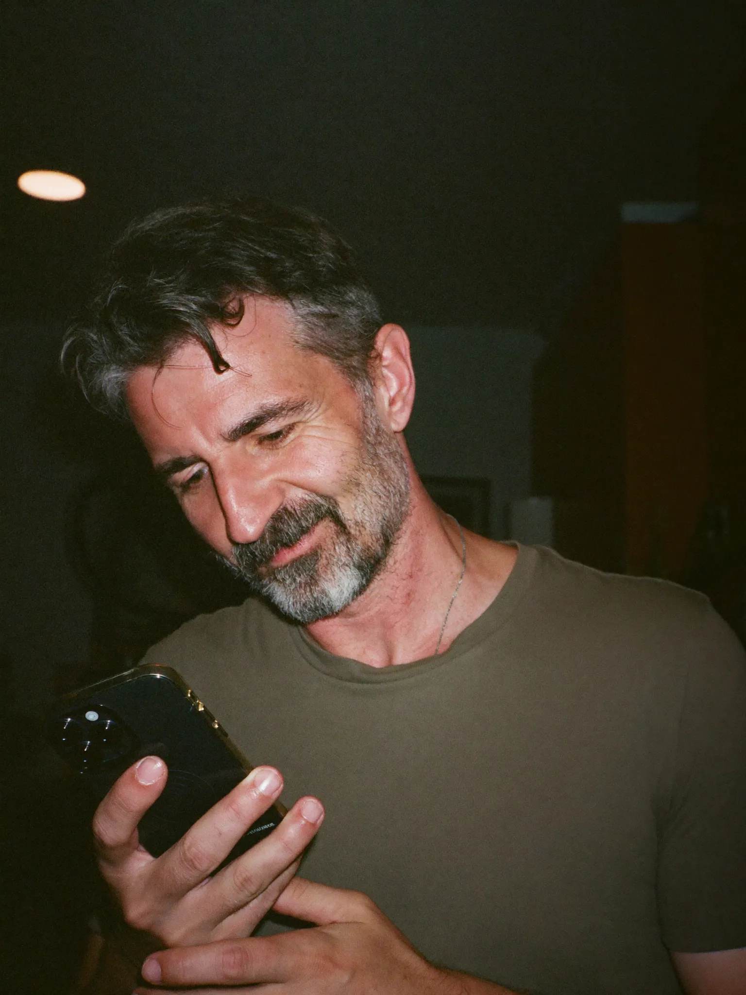 A business owner calmly reading a verified alert on his phone at night