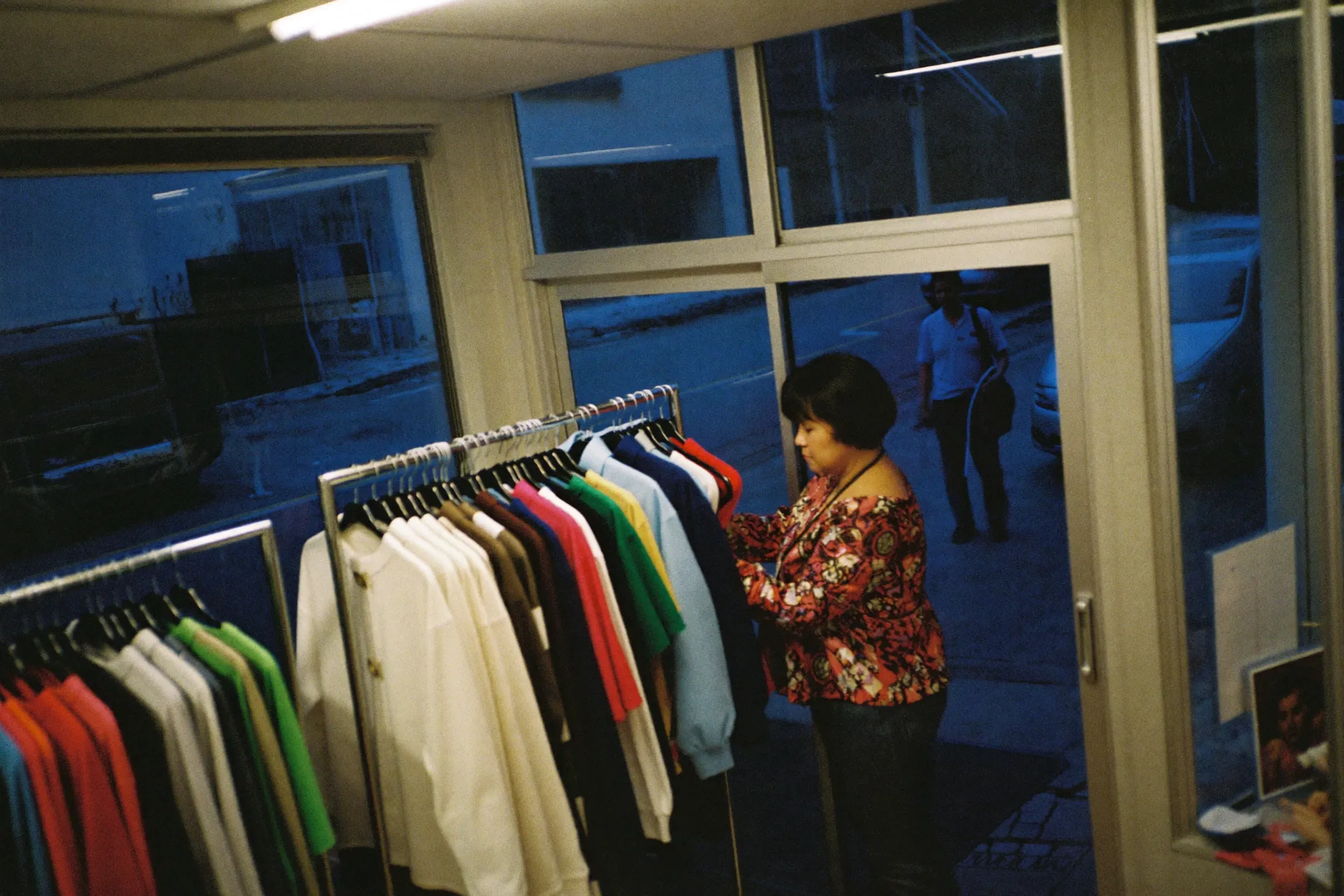 A shop owner closing up her retail store at dusk