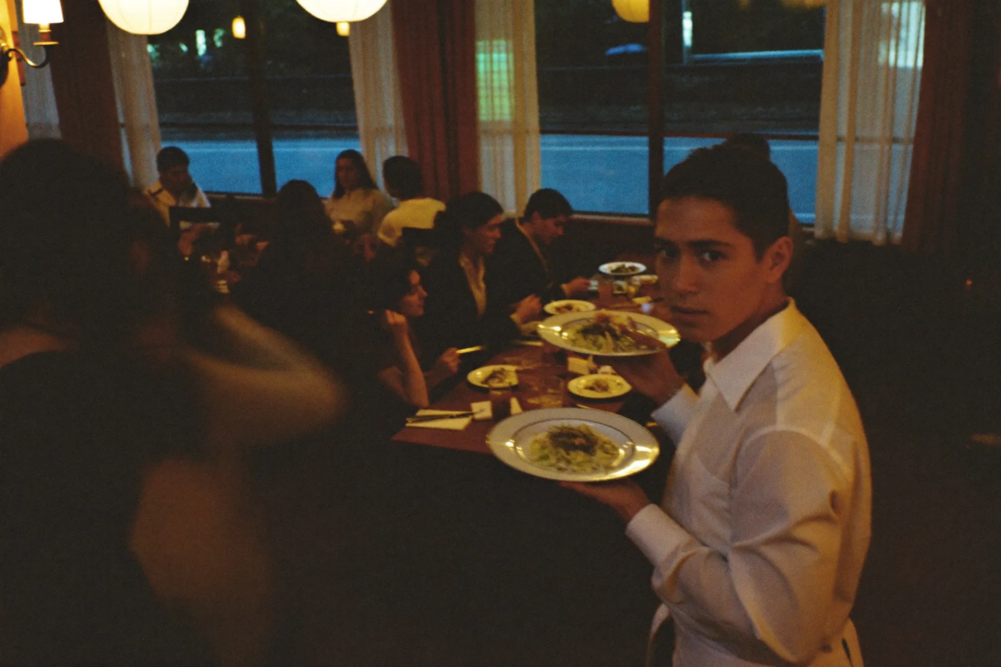 A waiter serving tables during evening service at a restaurant