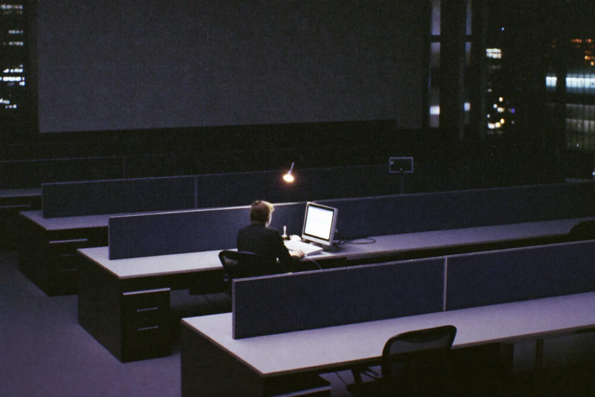 An employee working late in an otherwise empty office