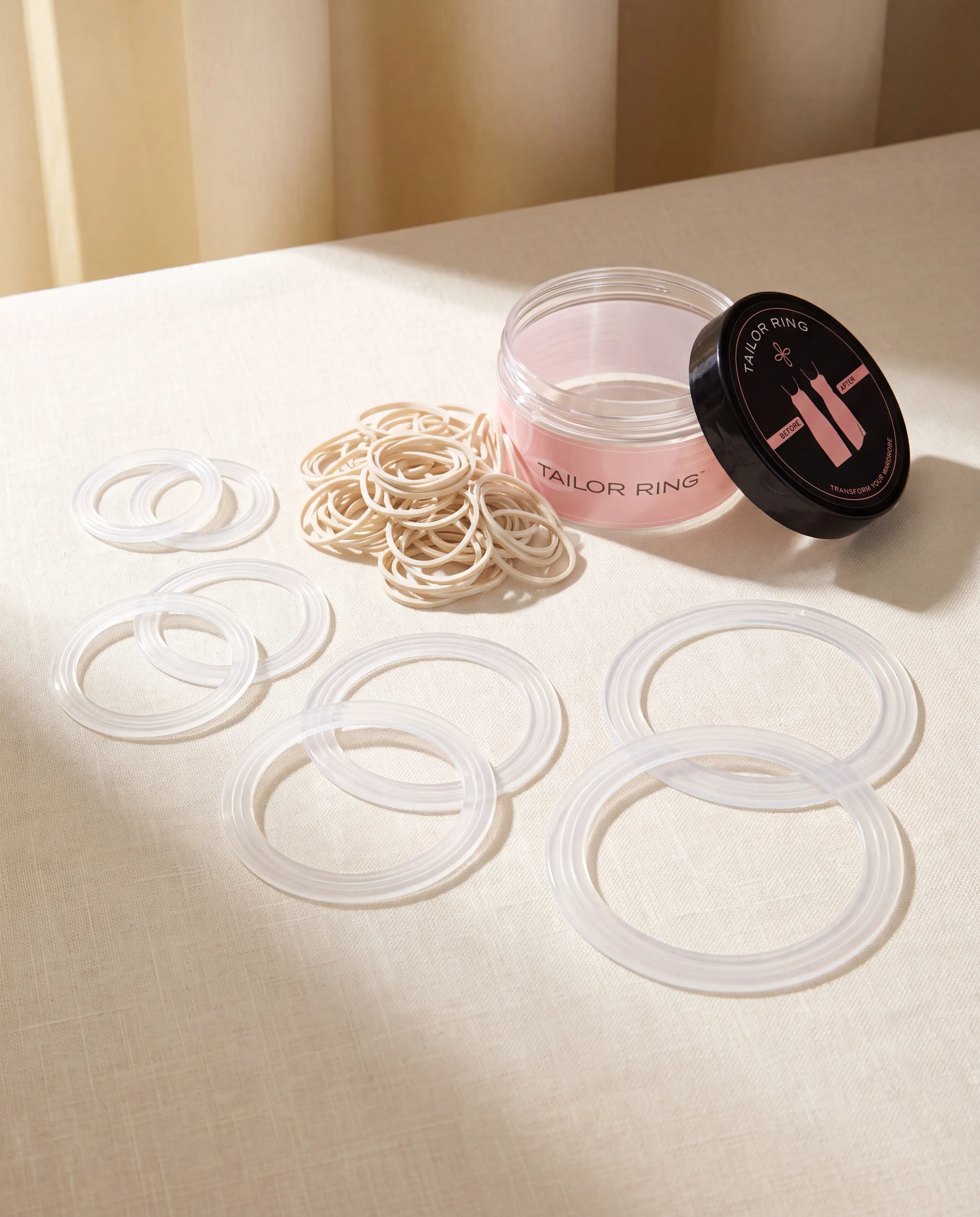 The complete Tailor Ring kit: eight clear rings in four sizes, elastic bands, and storage jar
