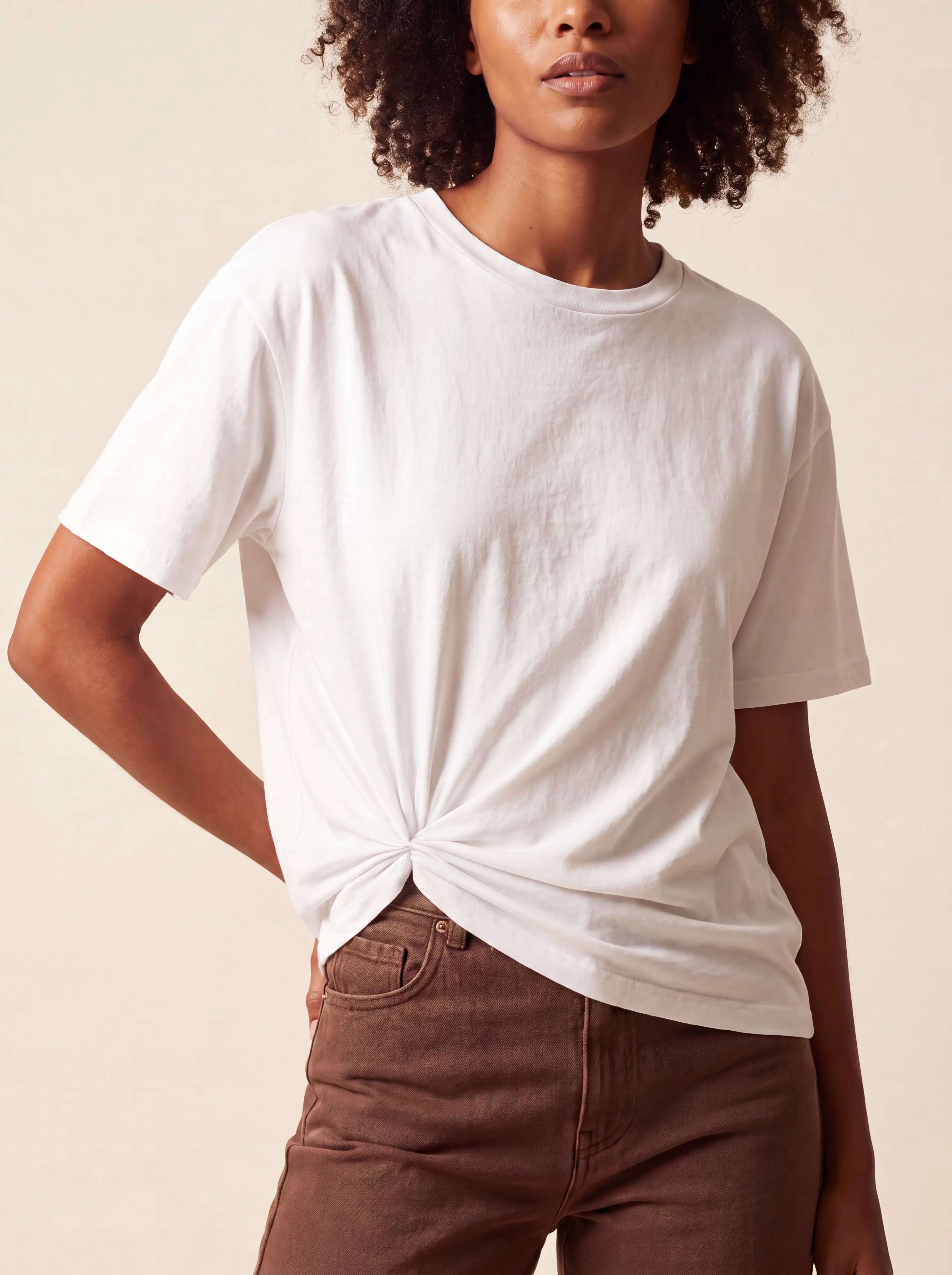 Model in a white tee cinched into a fitted crop with Tailor Ring