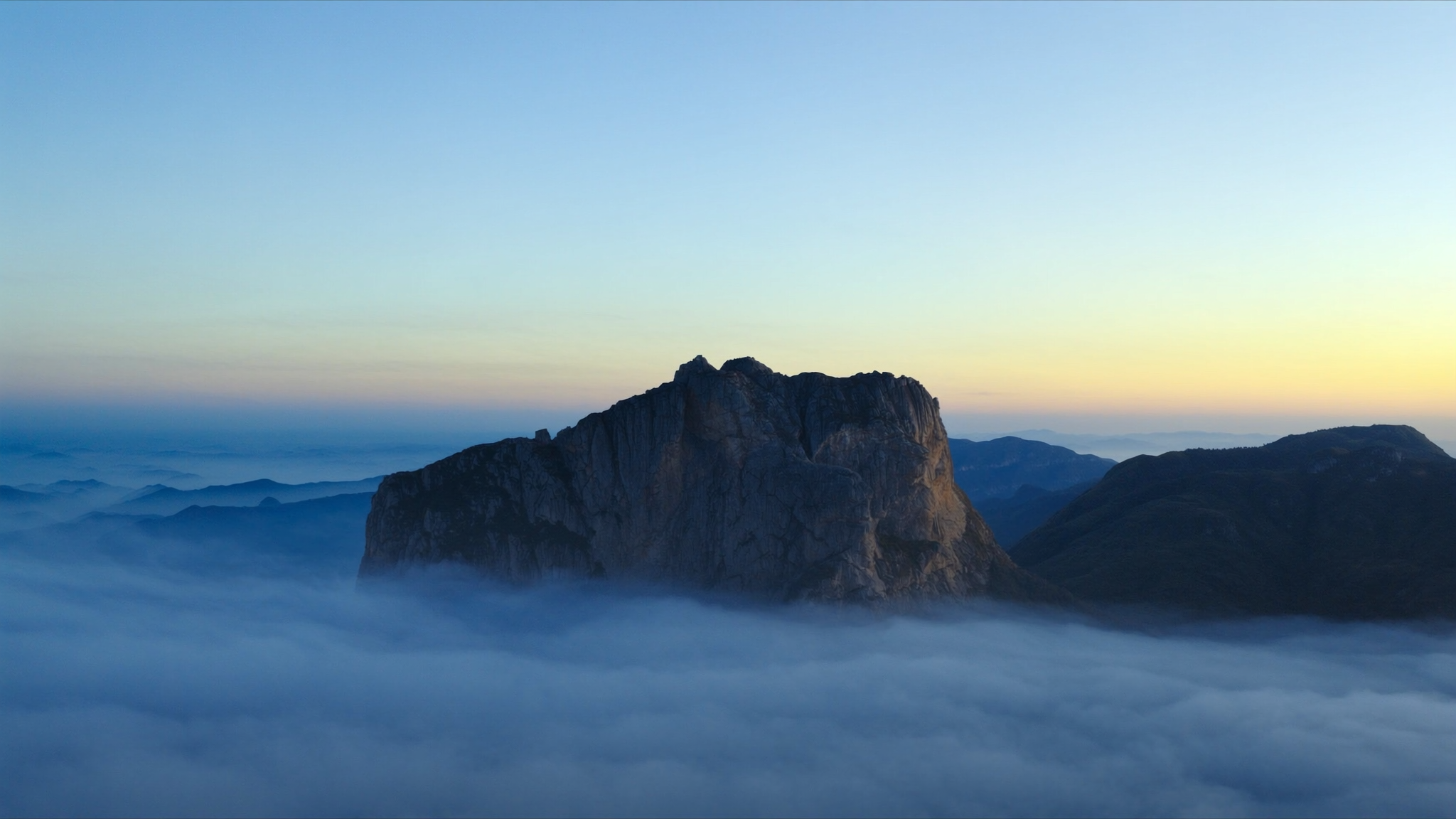 Pico da Bandeira acima de um mar de nuvens ao amanhecer