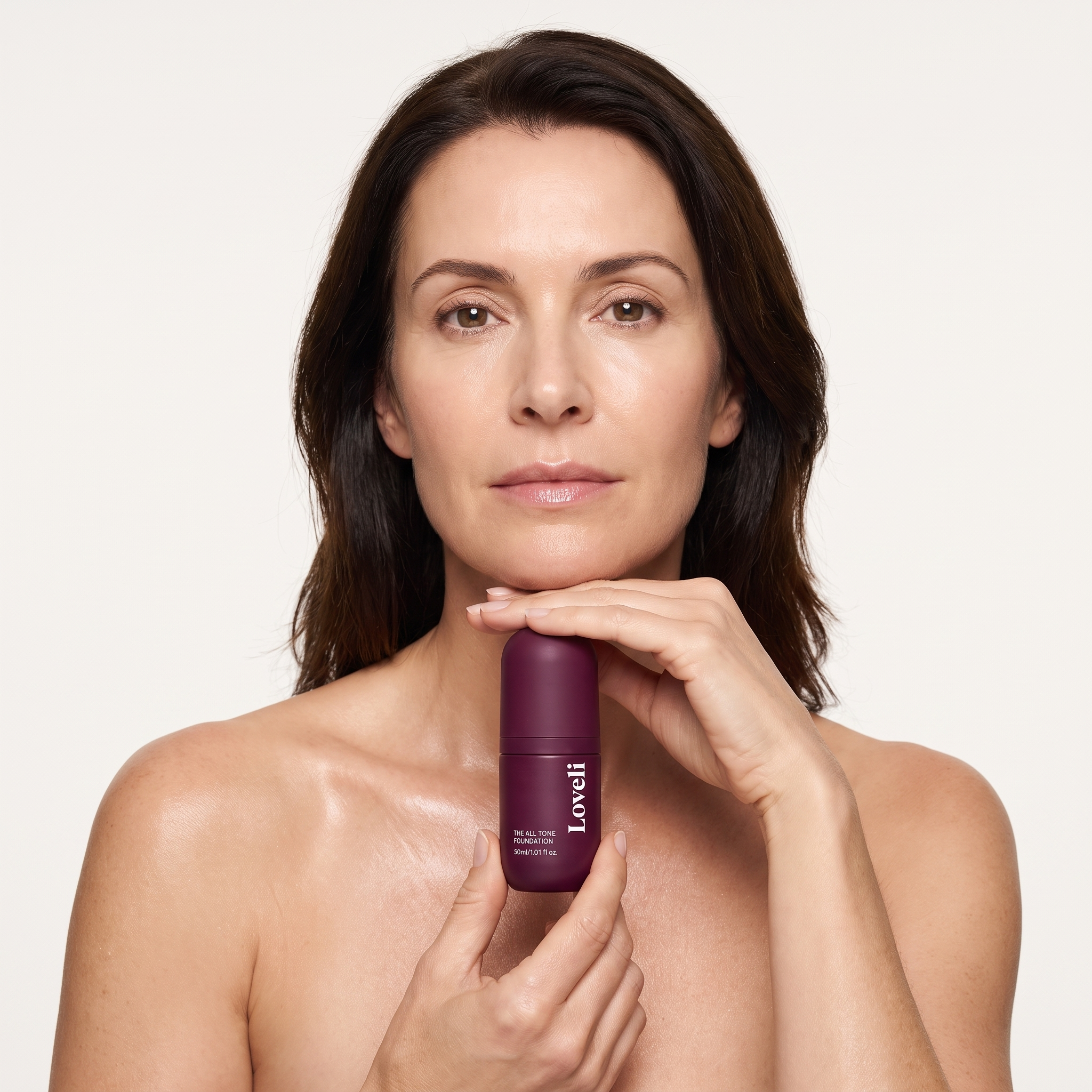 Woman with glowing skin holding the Loveli foundation