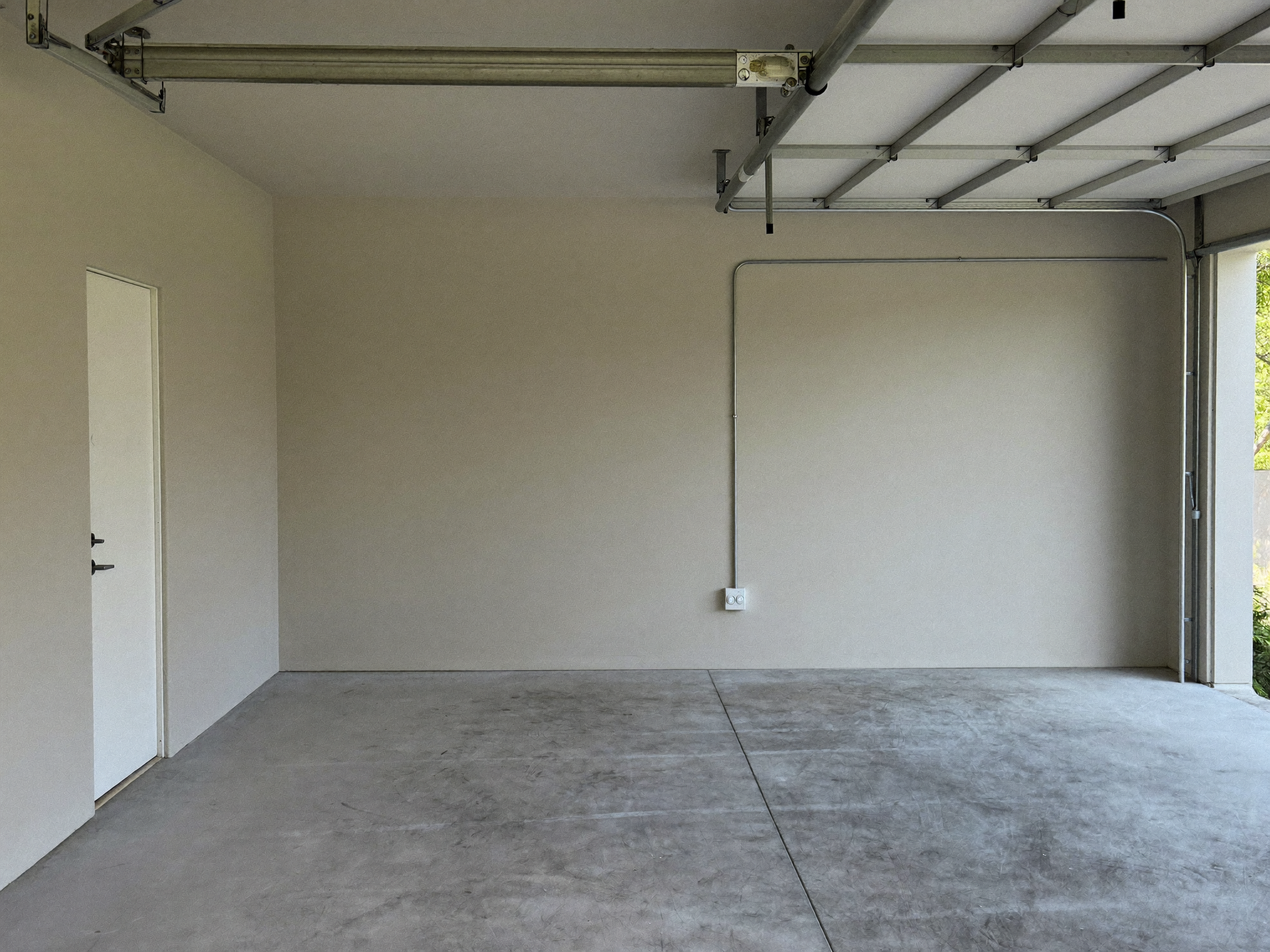 Finished new-build garage with a capped conduit stub ready for a future EV charger