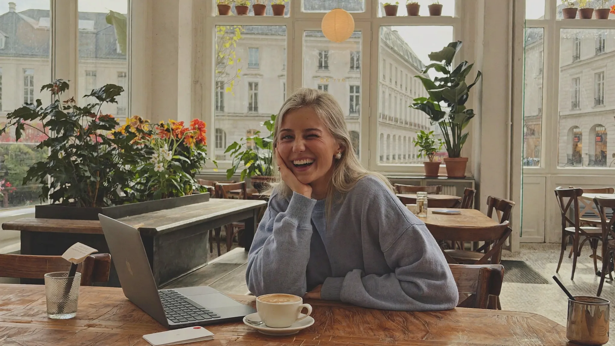 KI-generierte Markenbotschafterin lacht im hellen Café — Lifestyle-Content
