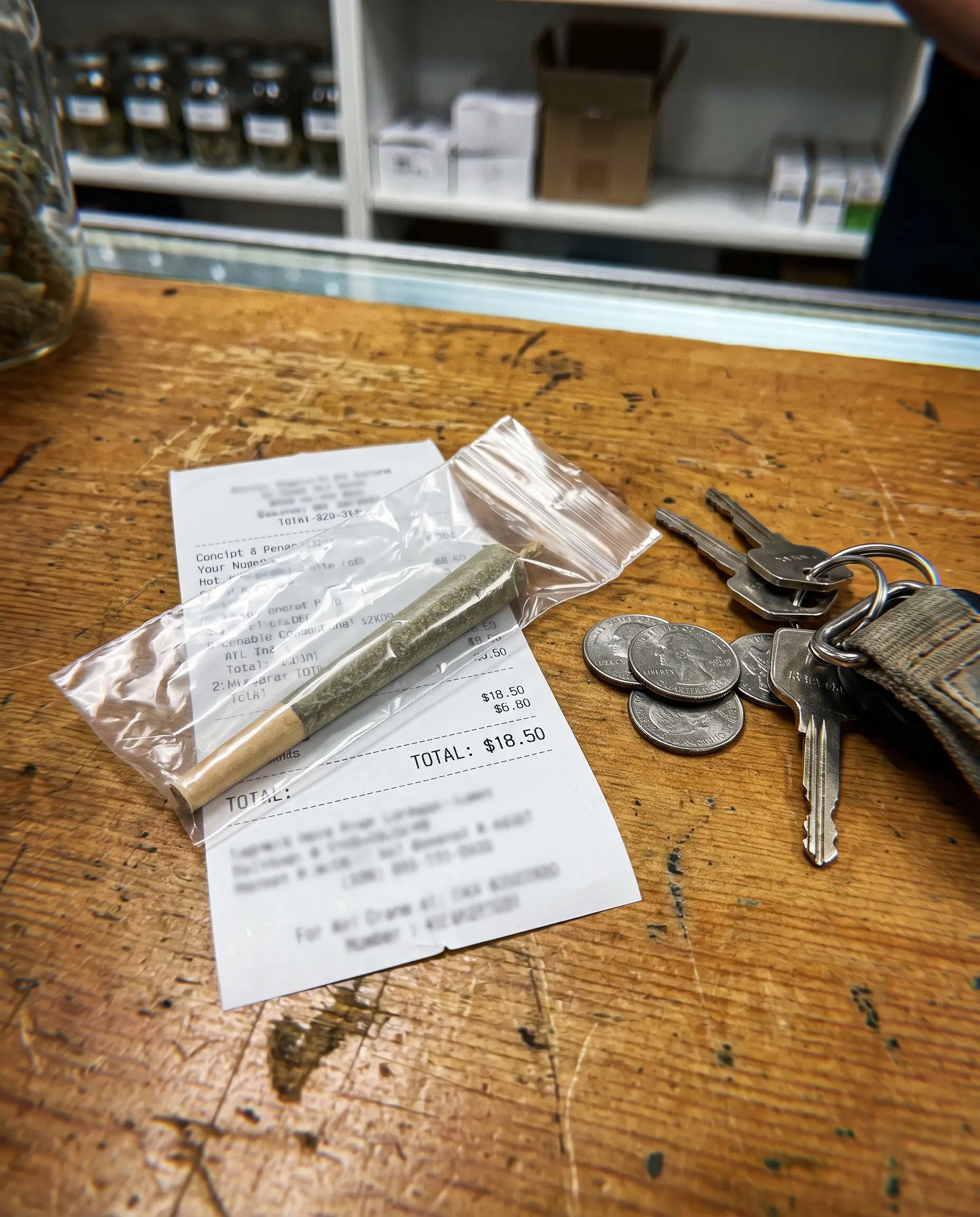 One pre-roll in a plain bag next to a receipt