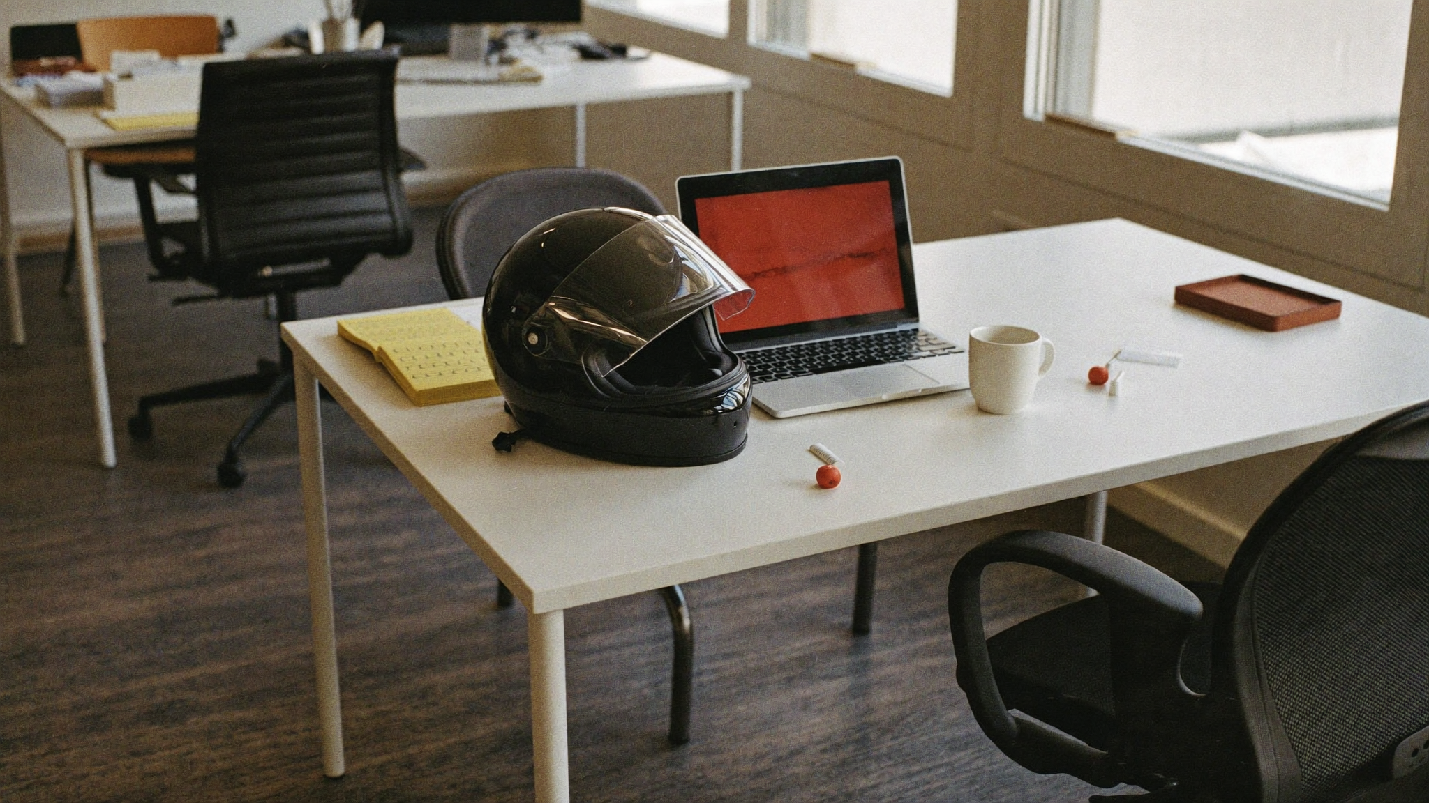 A motorcycle helmet on an ordinary office desk beside a laptop