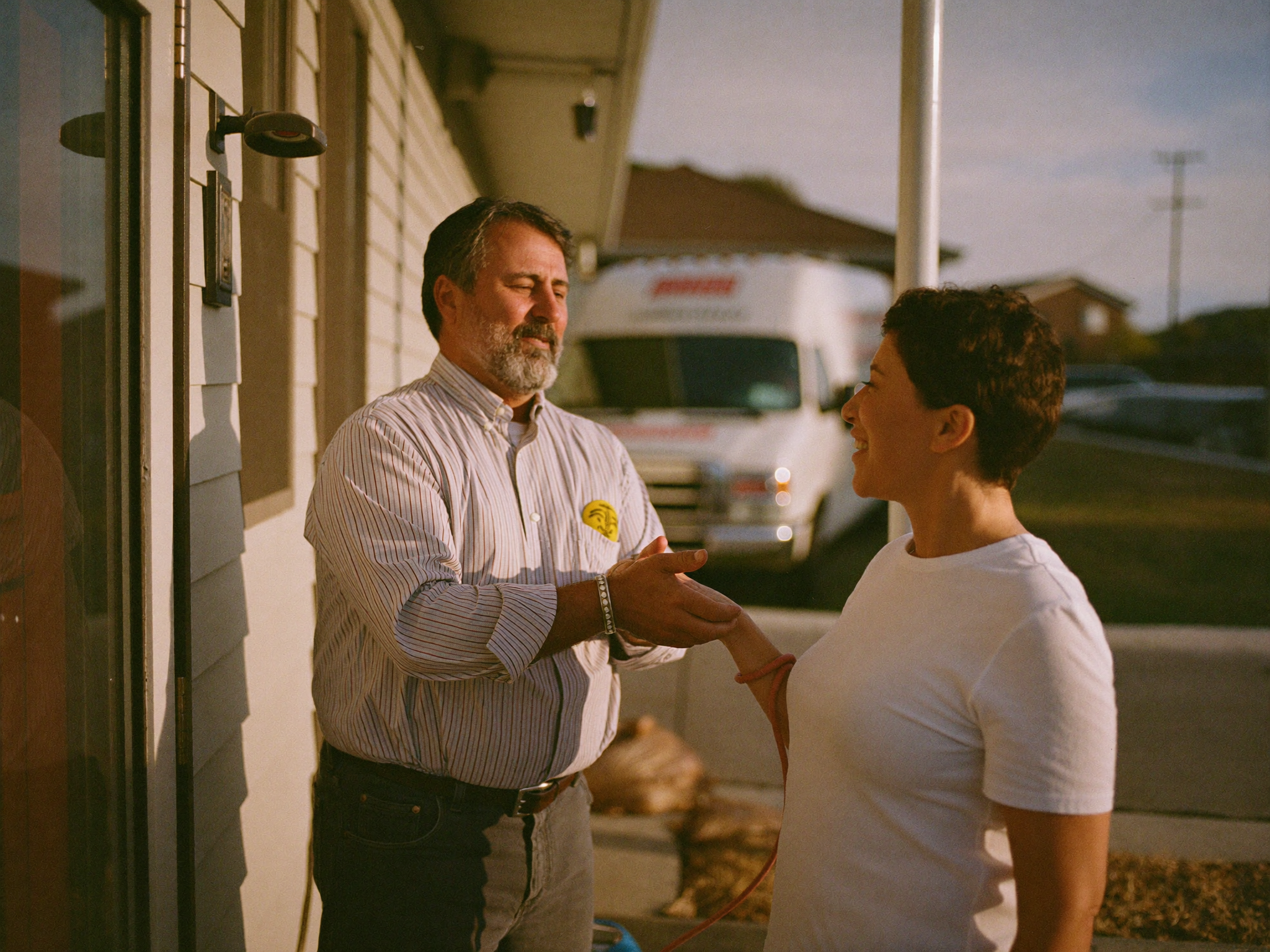 A plumbing business owner talking with a homeowner at her front door