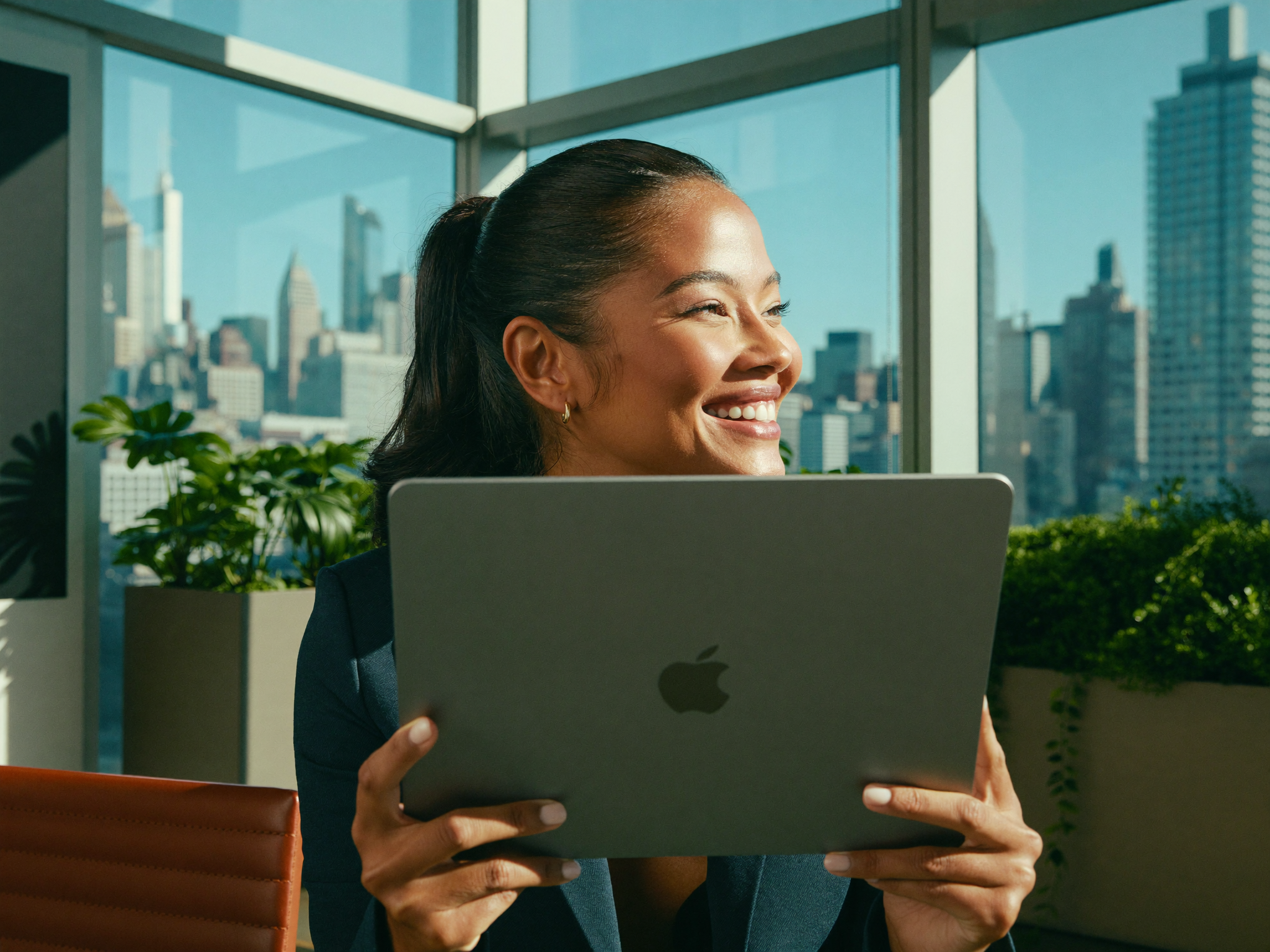 Happy broker holding a tablet and smiling by a bright office window