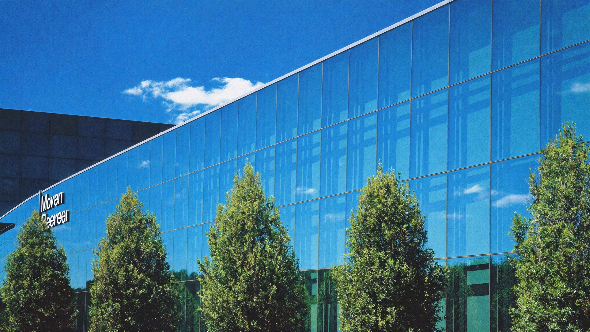 Modern corporate glass building exterior reflecting the sky