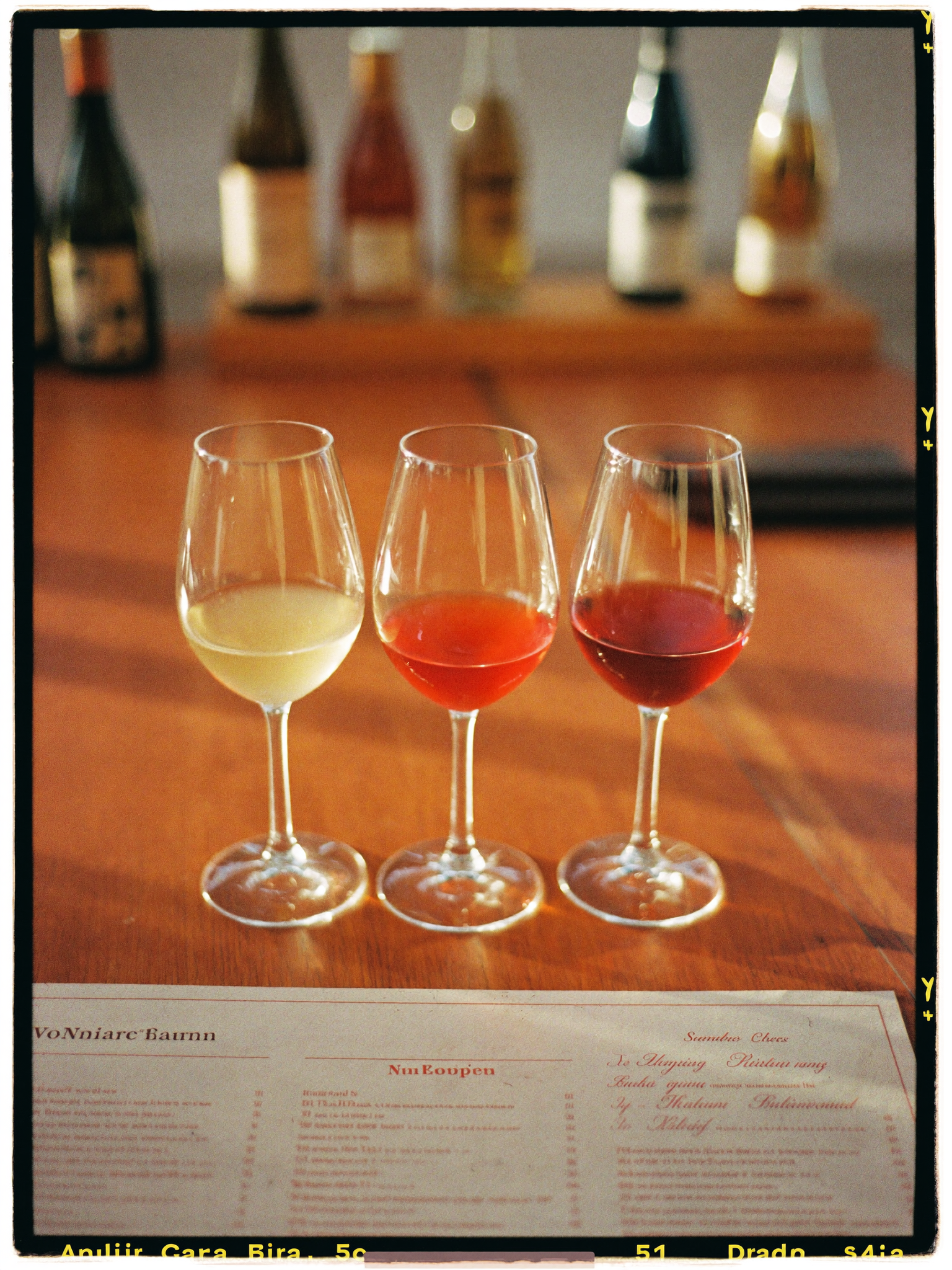 Three glasses of wine on a warm sunlit table