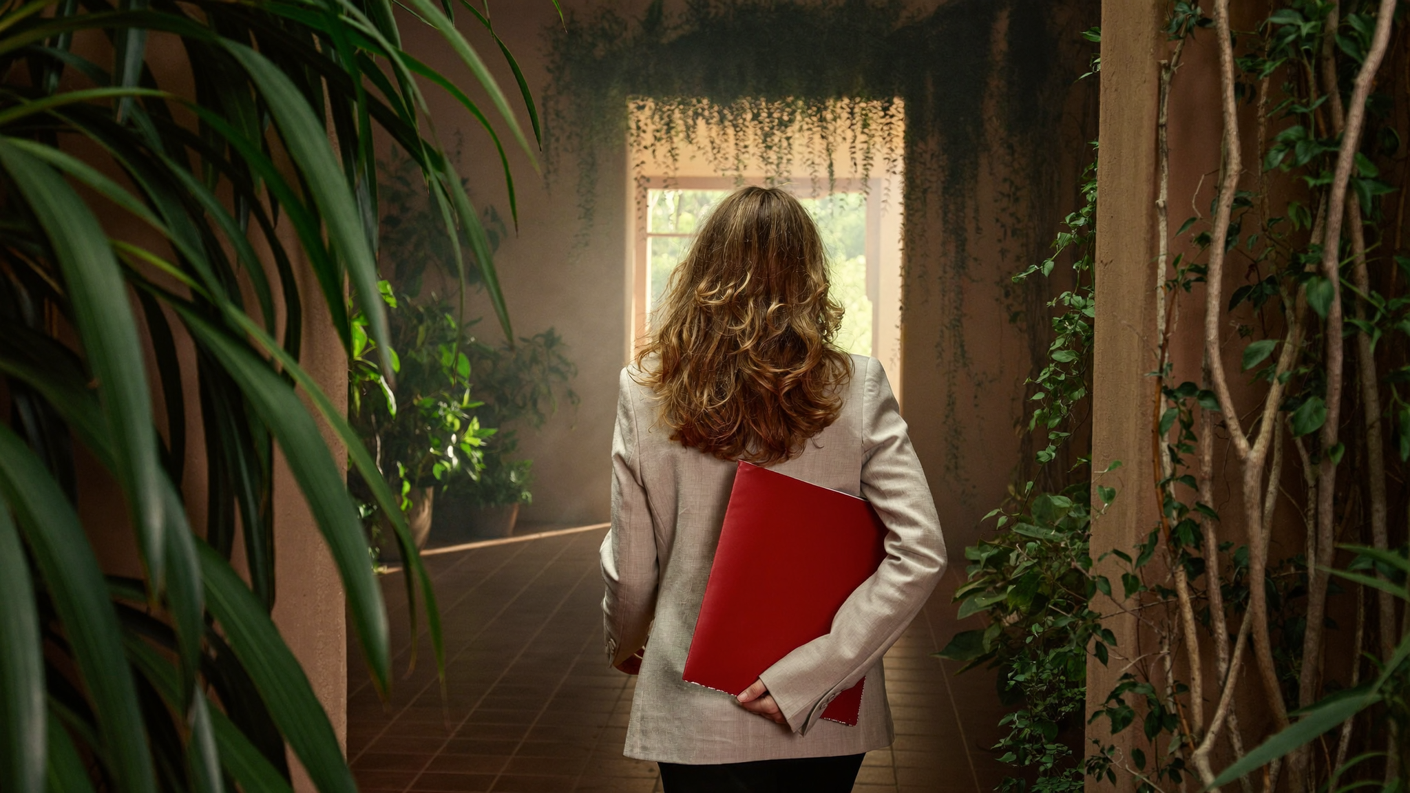 South African professional considering a career move at a sunlit desk with greenery