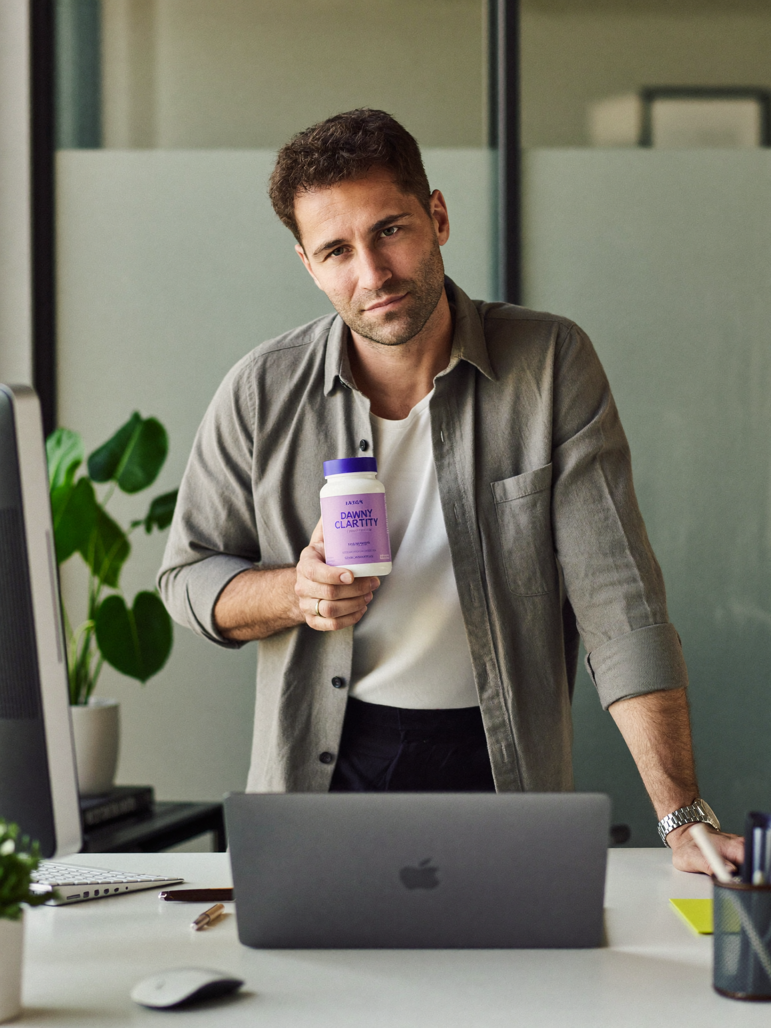 A product manager holding Dawnly Clarity+ at his standing desk.