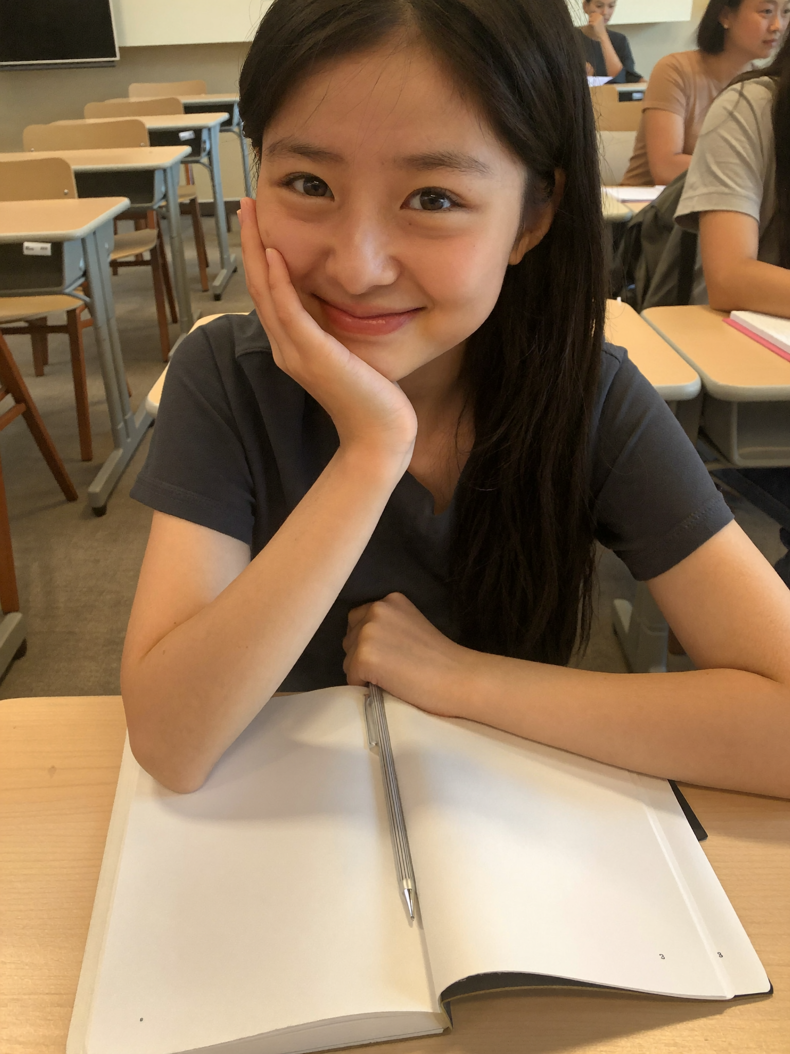A university student smiling at her desk during a study session.