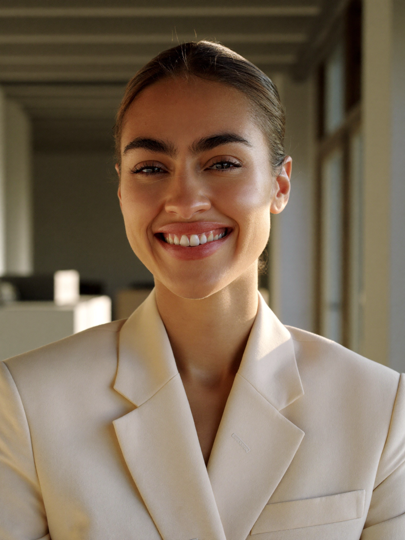 A professional woman smiling in a modern office.
