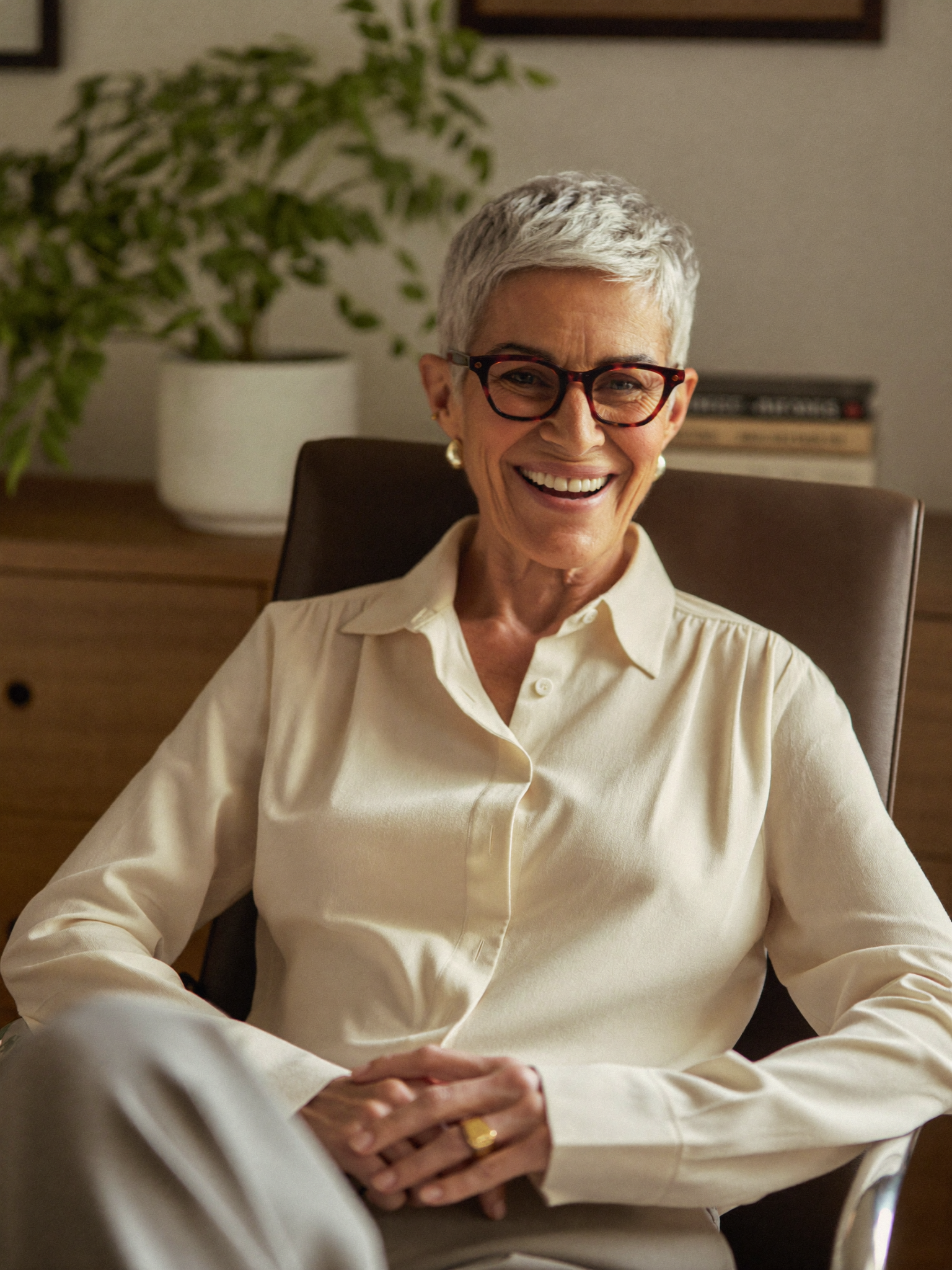 A confident entrepreneur smiling warmly in her office.