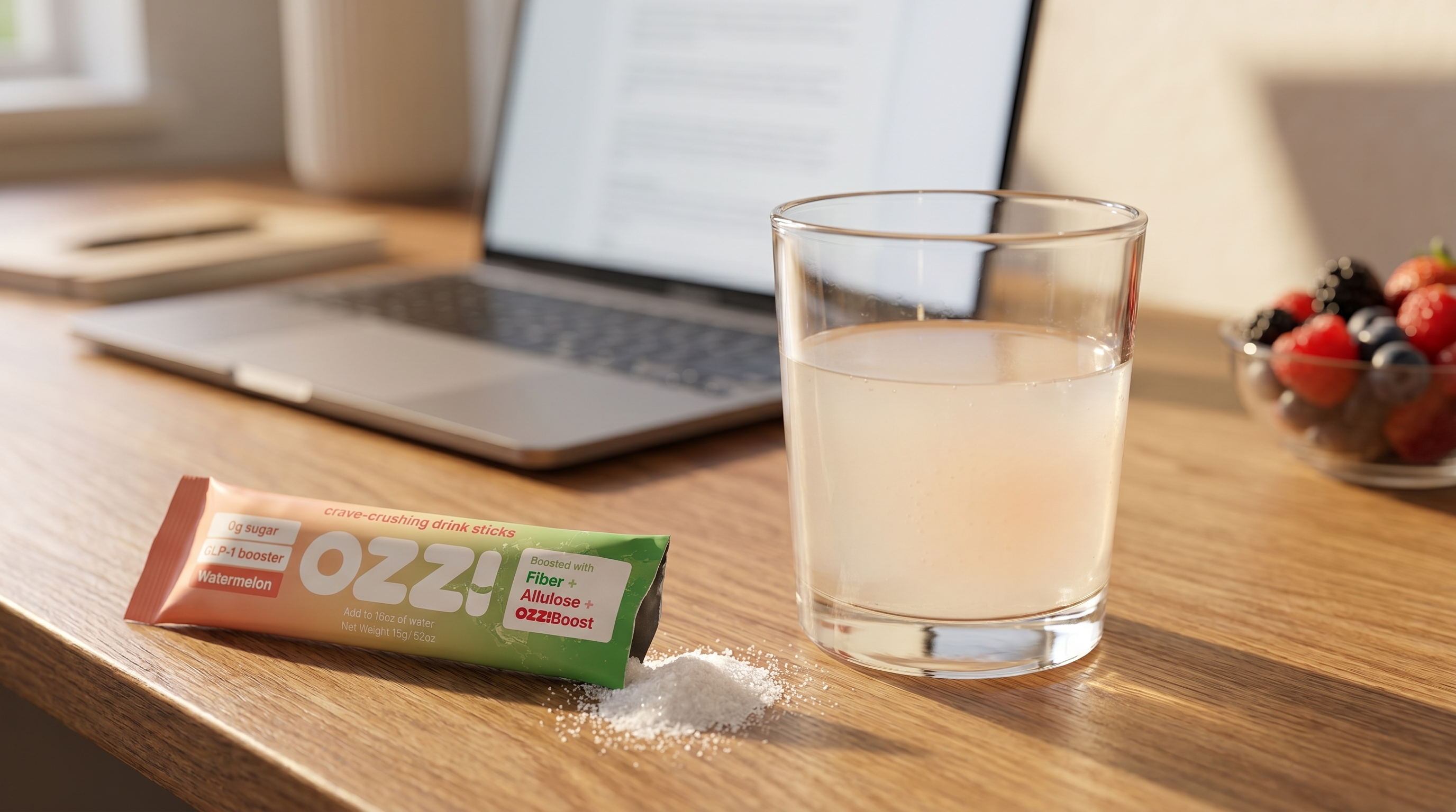Glass of prepared Ozzi drink and a torn Ozzi stick pack on a home office desk