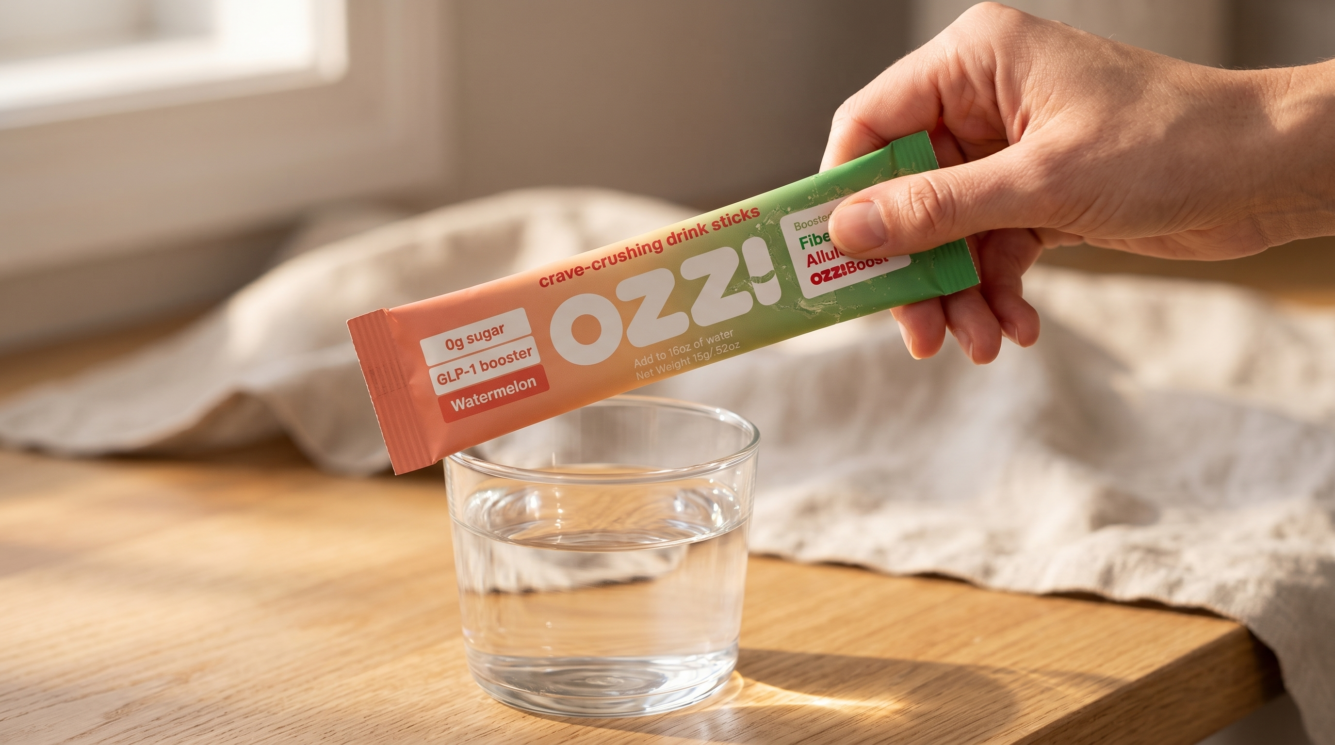 Single Ozzi Crave Crusher watermelon stick pack held in hand on a sunlit kitchen counter