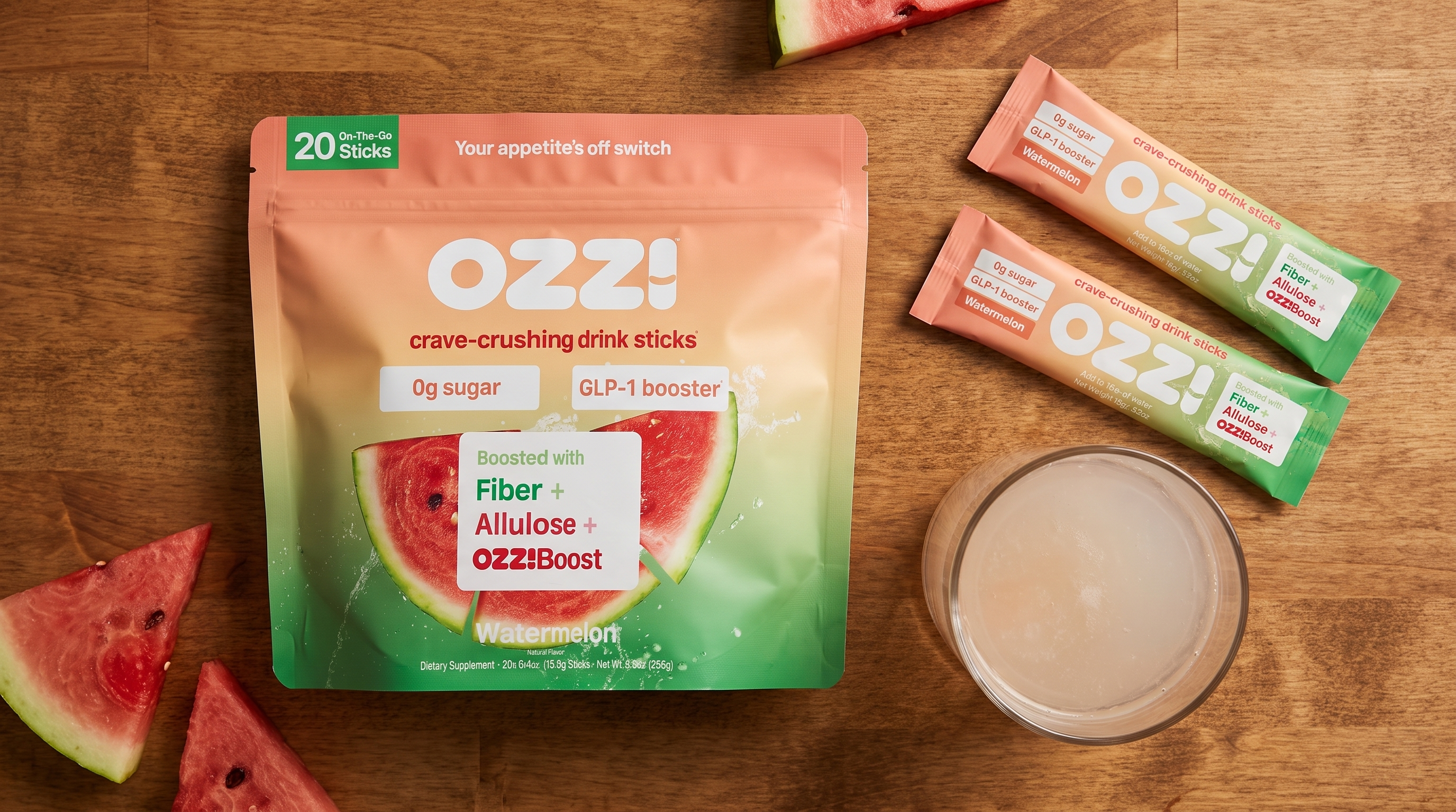 Ozzi watermelon pouch, drink sticks, and a glass of the prepared drink on a kitchen counter