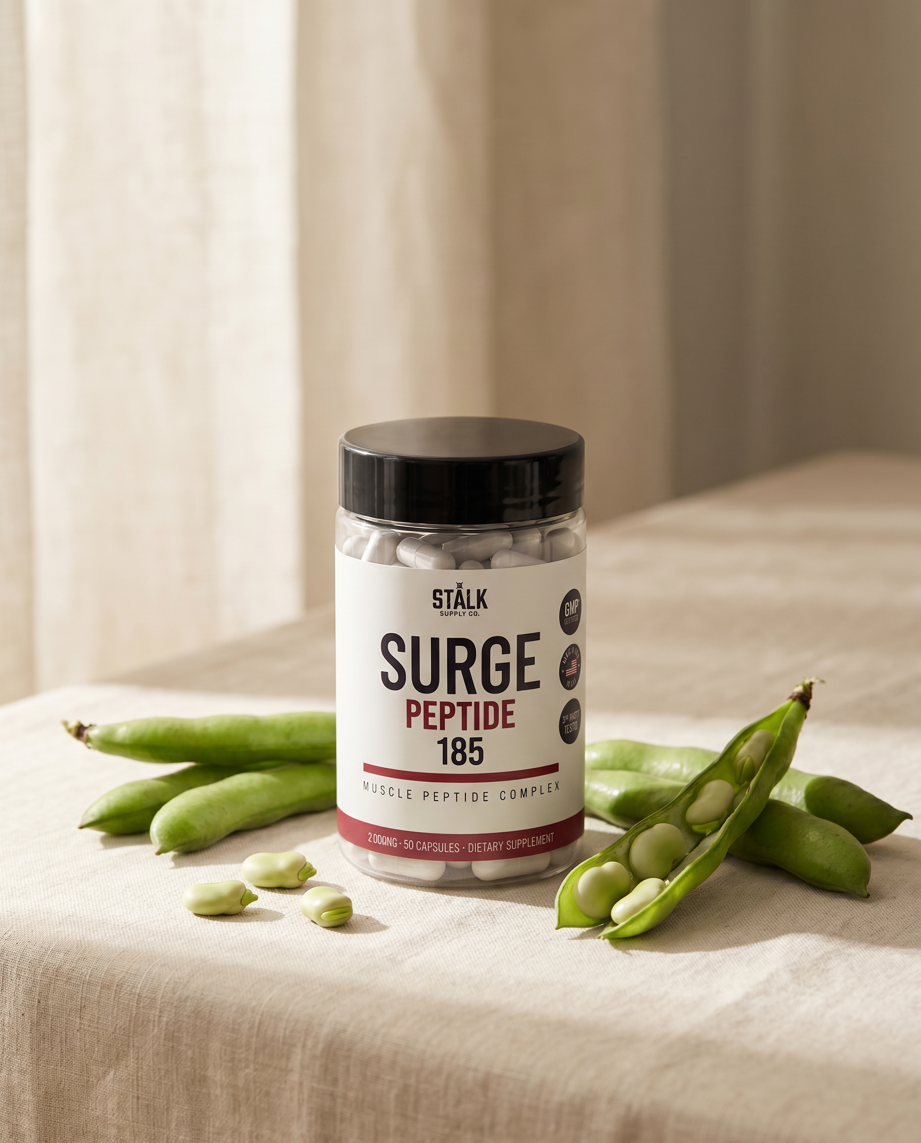 SURGE 185 bottle beside fresh fava bean pods
