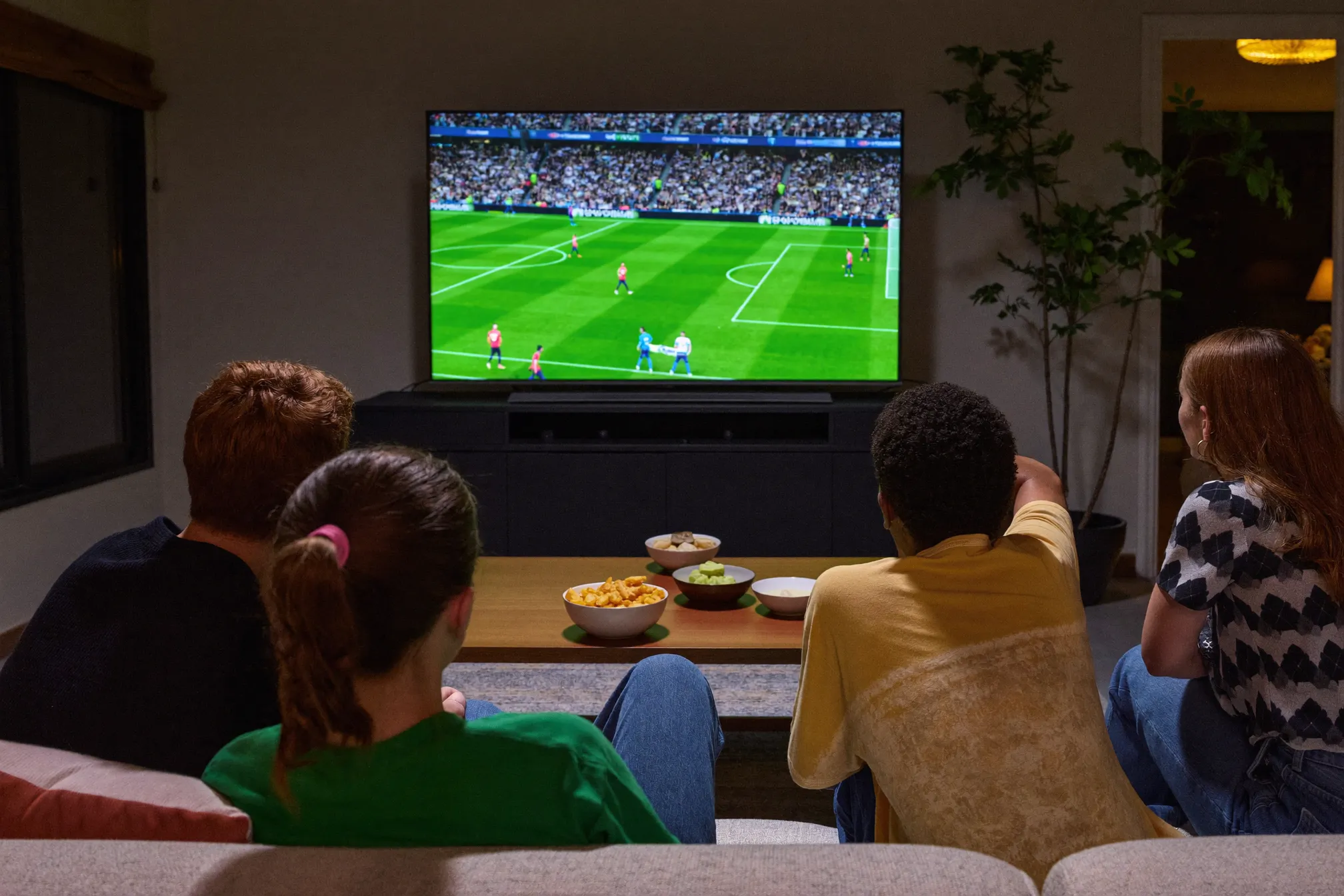 Famille devant un match de football diffusé en IPTV un dimanche soir