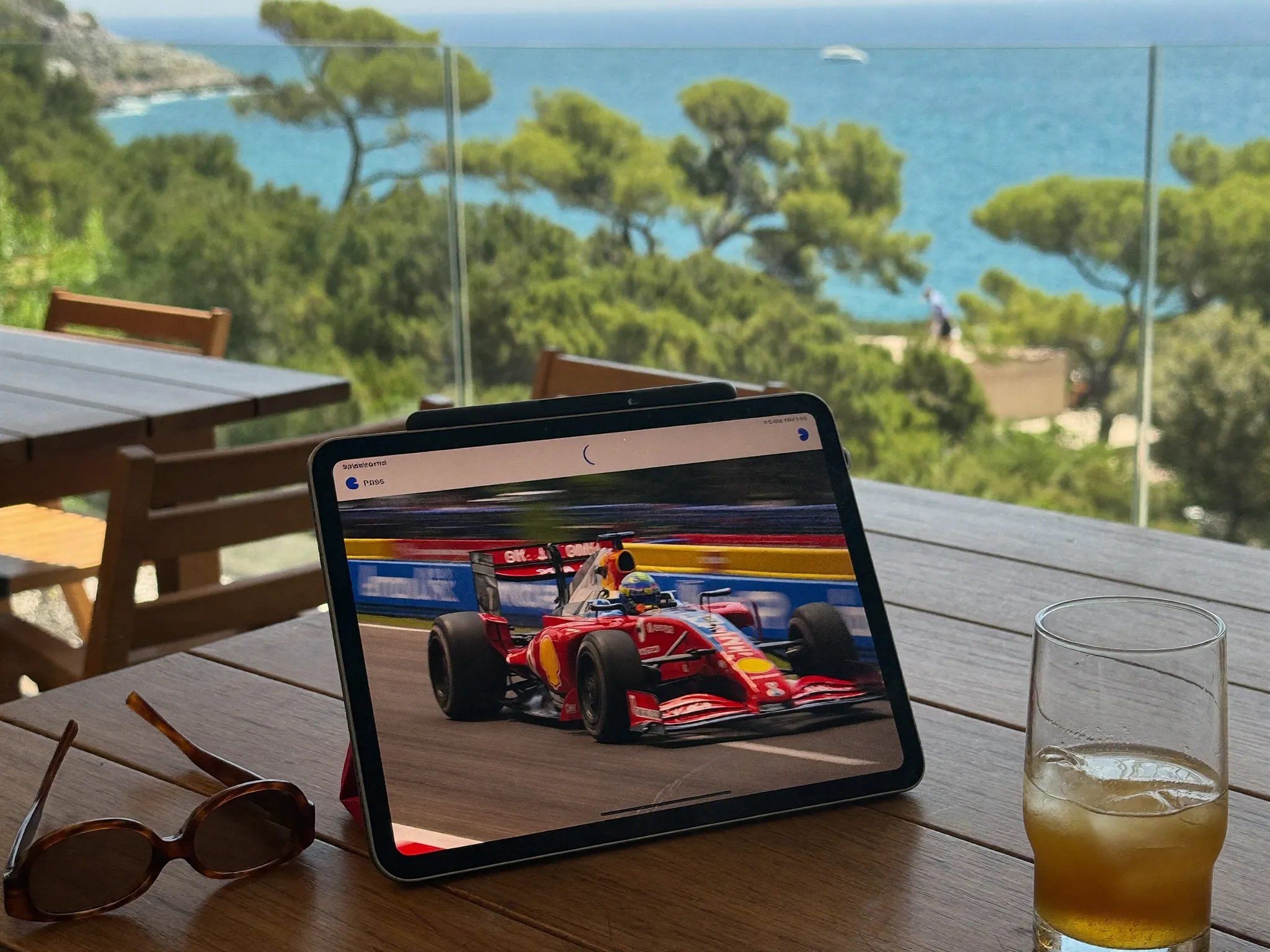 Tablette sur une terrasse d'été qui diffuse une course automobile, l'abonnement IPTV 12 mois fonctionne aussi en vacances