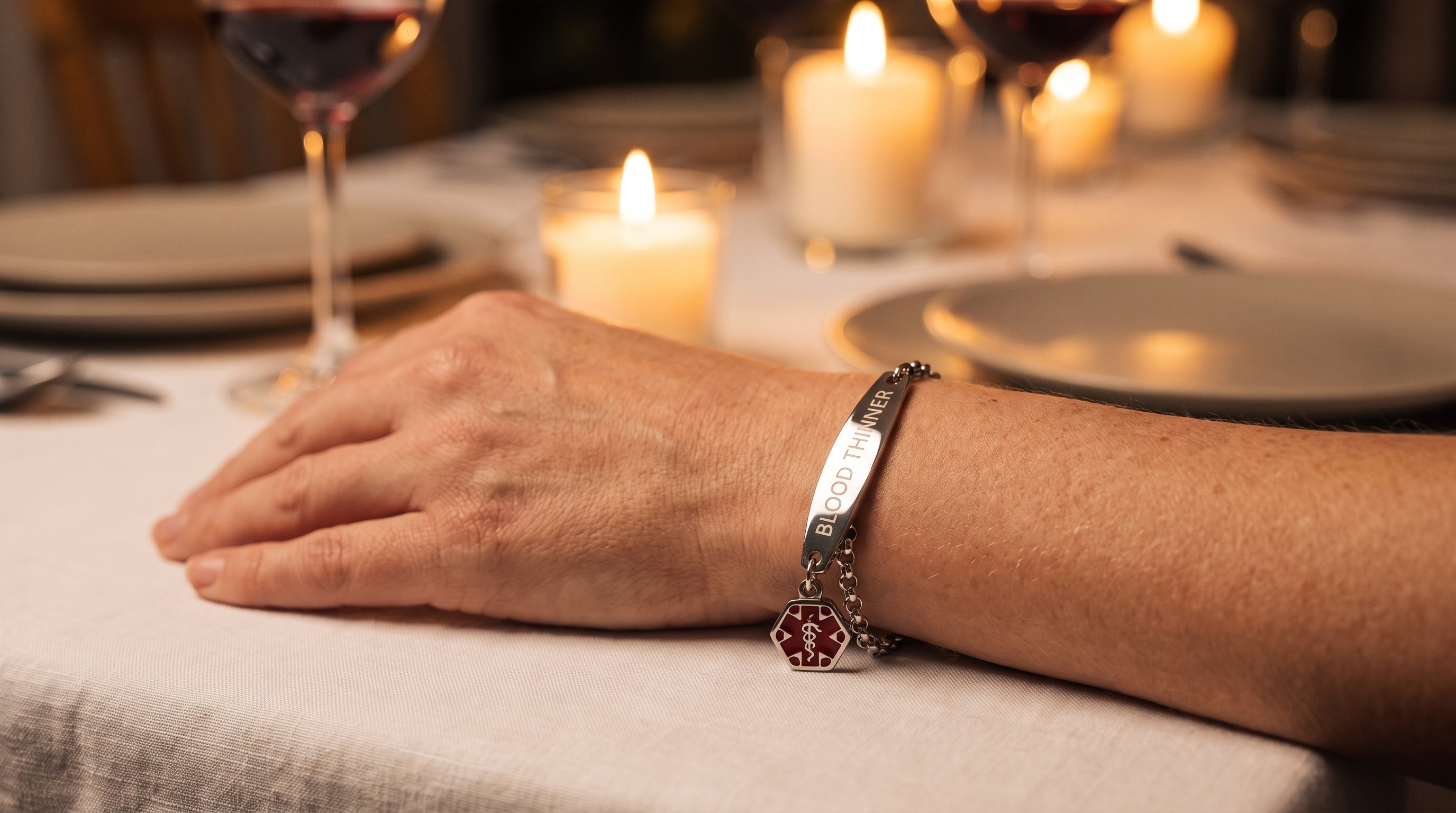 Woman's wrist at a dinner table, bracelet catching candlelight, jewelry-grade lifestyle shot
