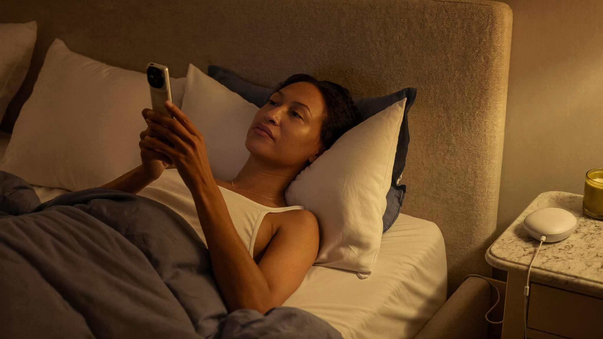 Woman relaxing on her bed with the device on the nightstand
