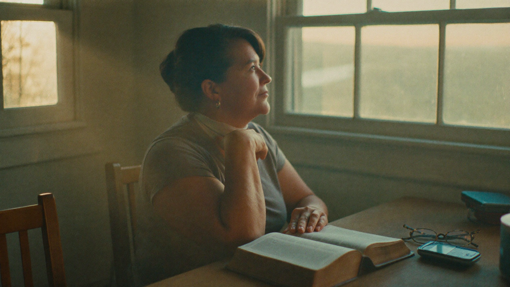 Open Bible and glucose meter on a kitchen table at dawn