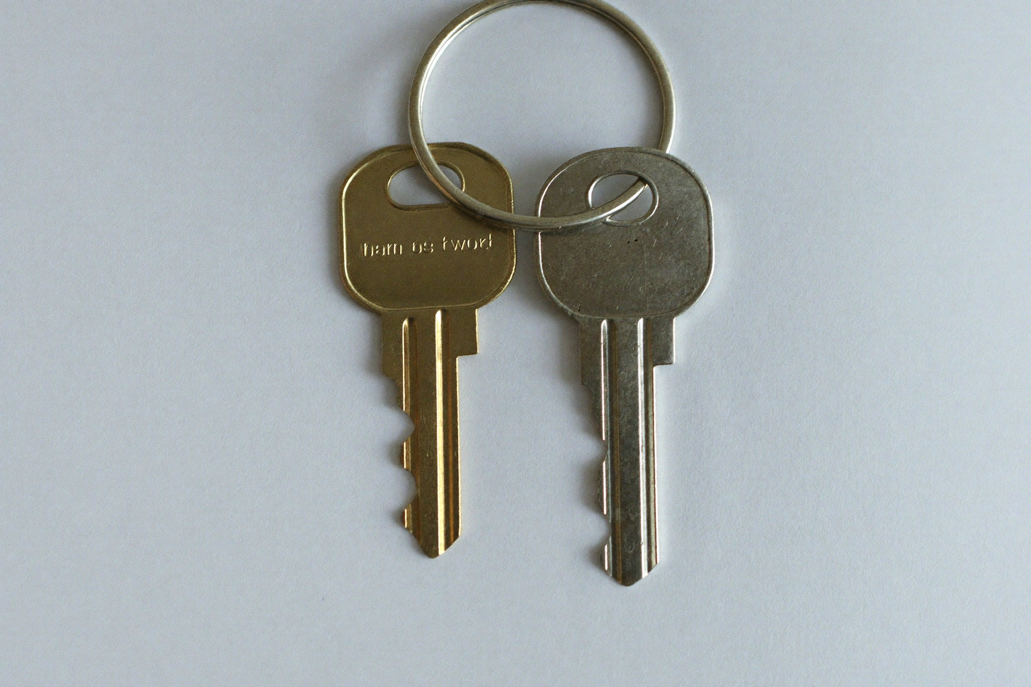 A key ring with two keys — one cut, one a blank