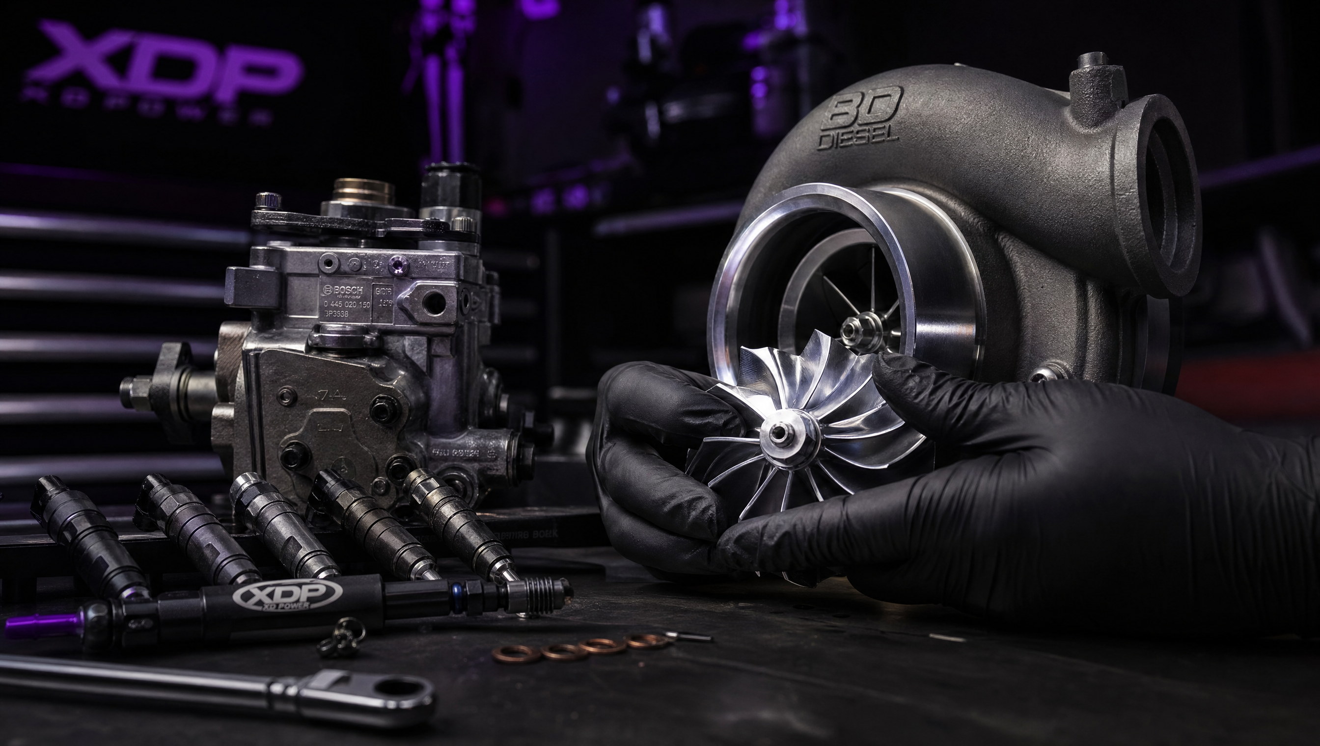 Performance turbocharger compressor wheel and fuel system components on workbench at Affliction Diesel