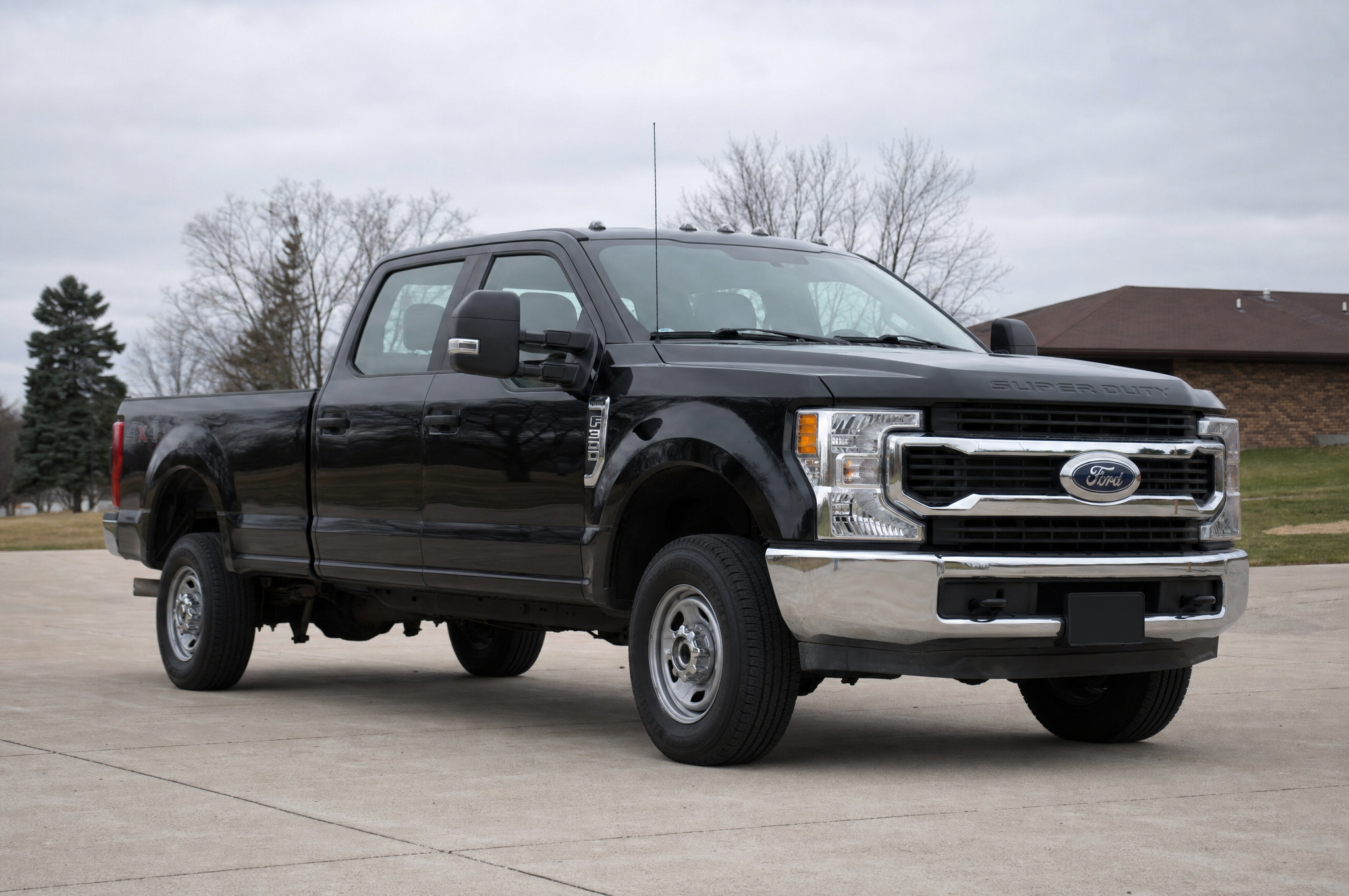 Stock black Ford F-250 Super Duty in a driveway on an overcast day