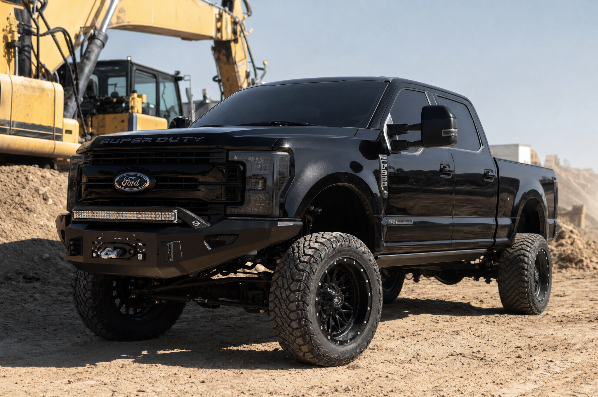 Modified black Ford F-250 Super Duty with lift kit and winch bumper at a construction site