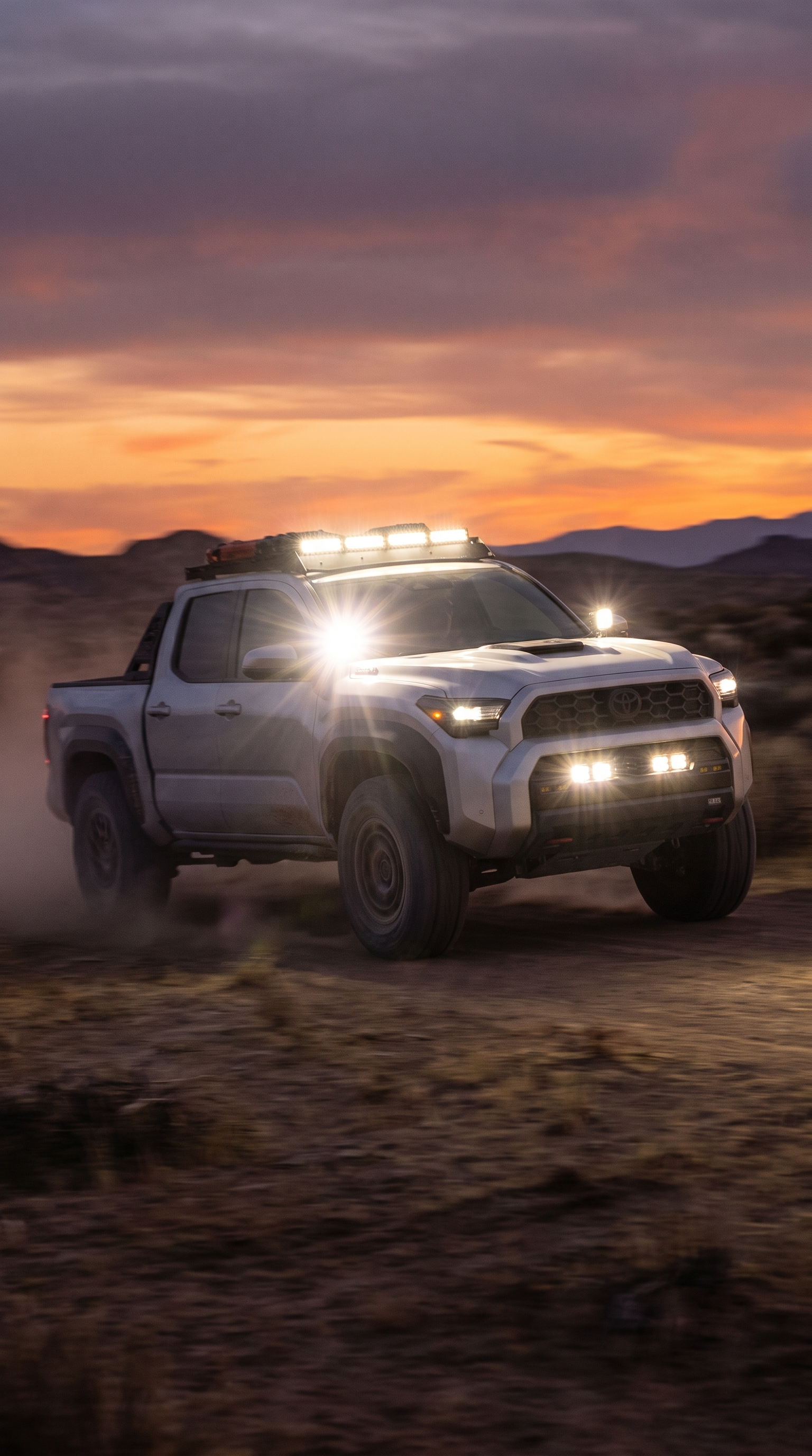 Toyota Tacoma with roof light bar and bumper light pods at sunset