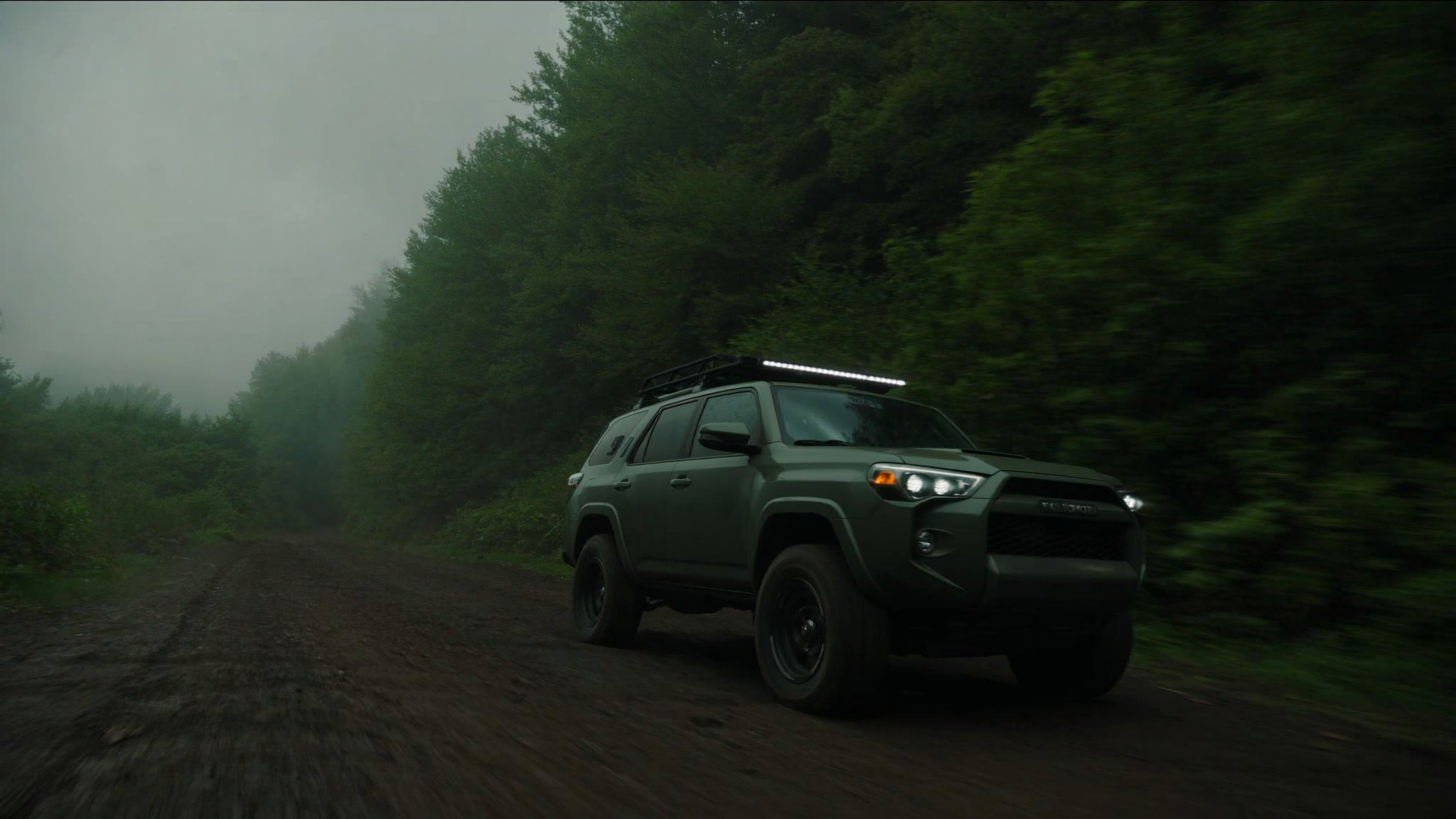Overland-built Toyota 4Runner driving a foggy Pacific Northwest forest trail