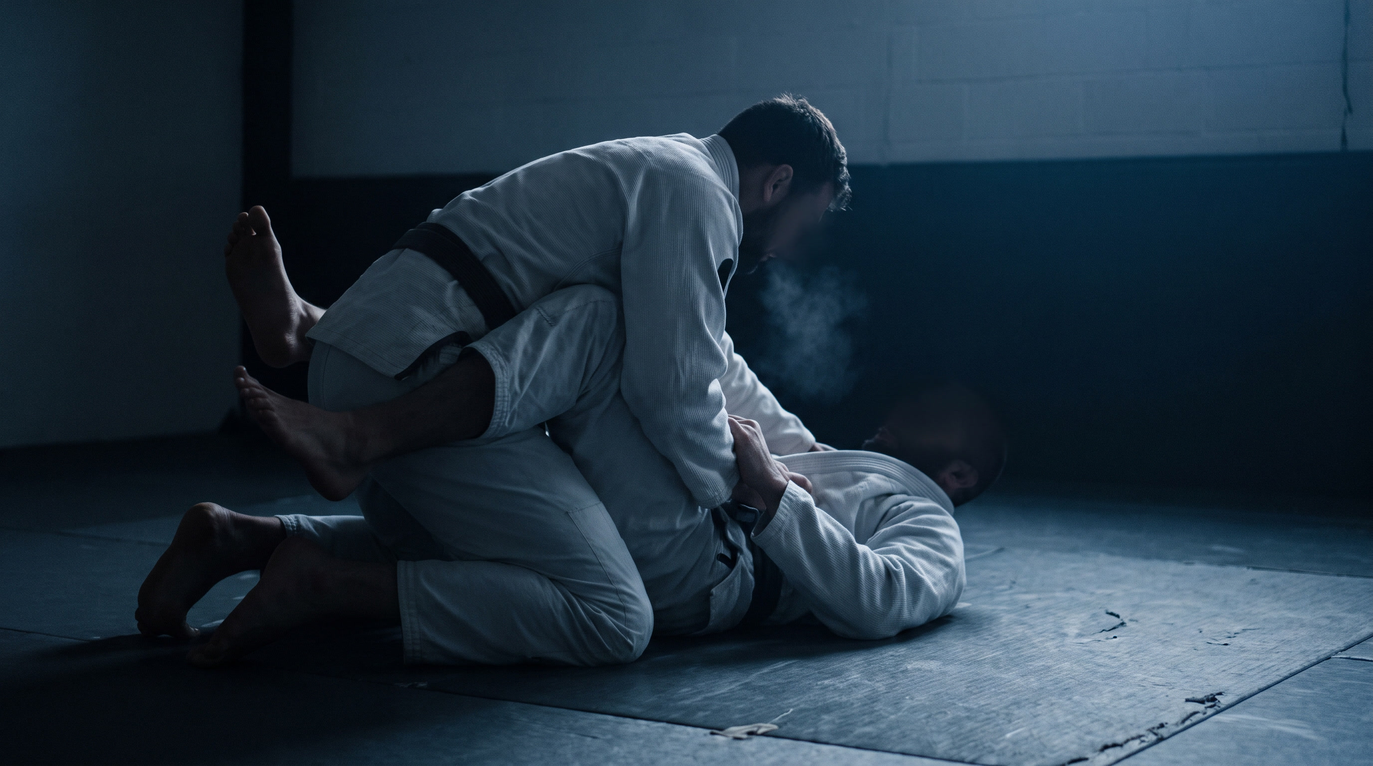 Two BJJ practitioners drilling a guard pass in a dark academy during winter competition training.