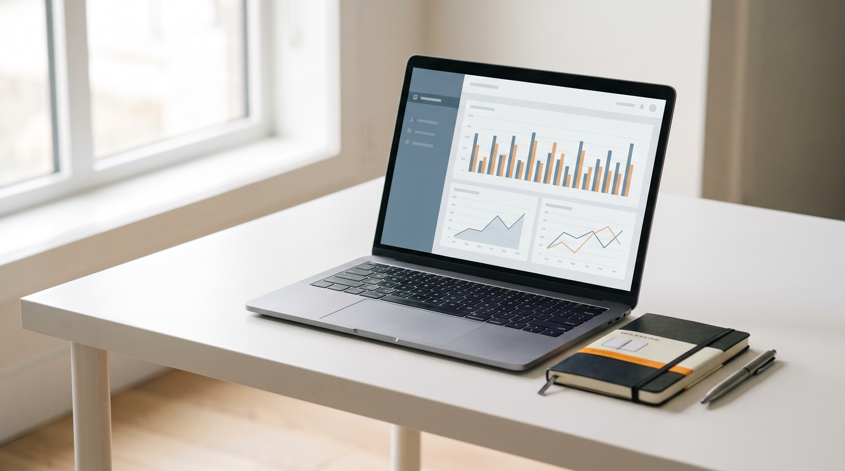 Tableau de bord d'analyse web minimaliste affiché sur un ordinateur portable posé sur un bureau clair.