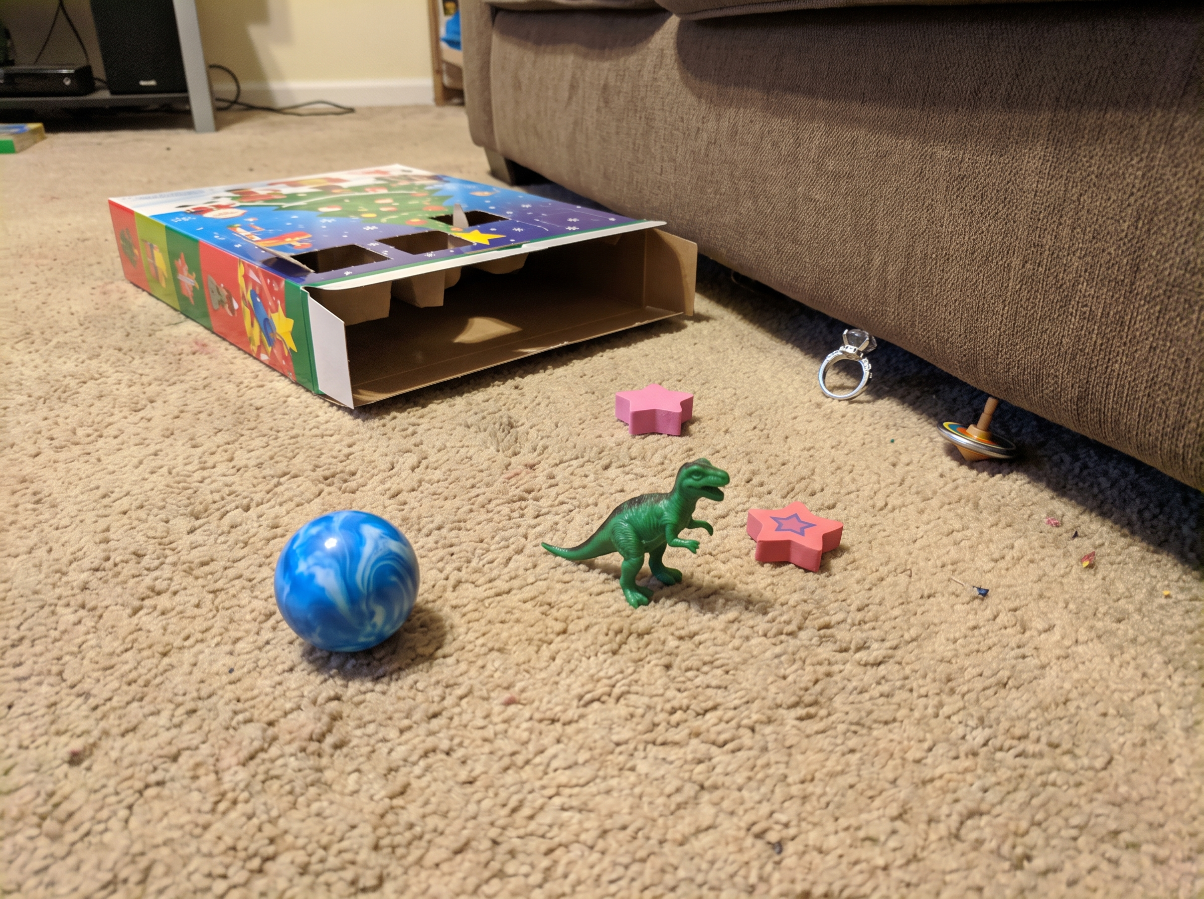 Trinkets spilled on the carpet — half already under the couch