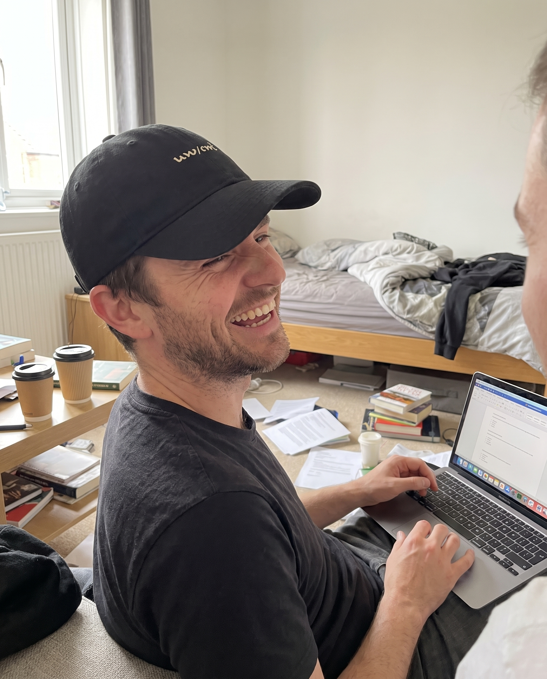 Man wearing the Halo Cap at his desk, visibly alert and engaged, laptop in use