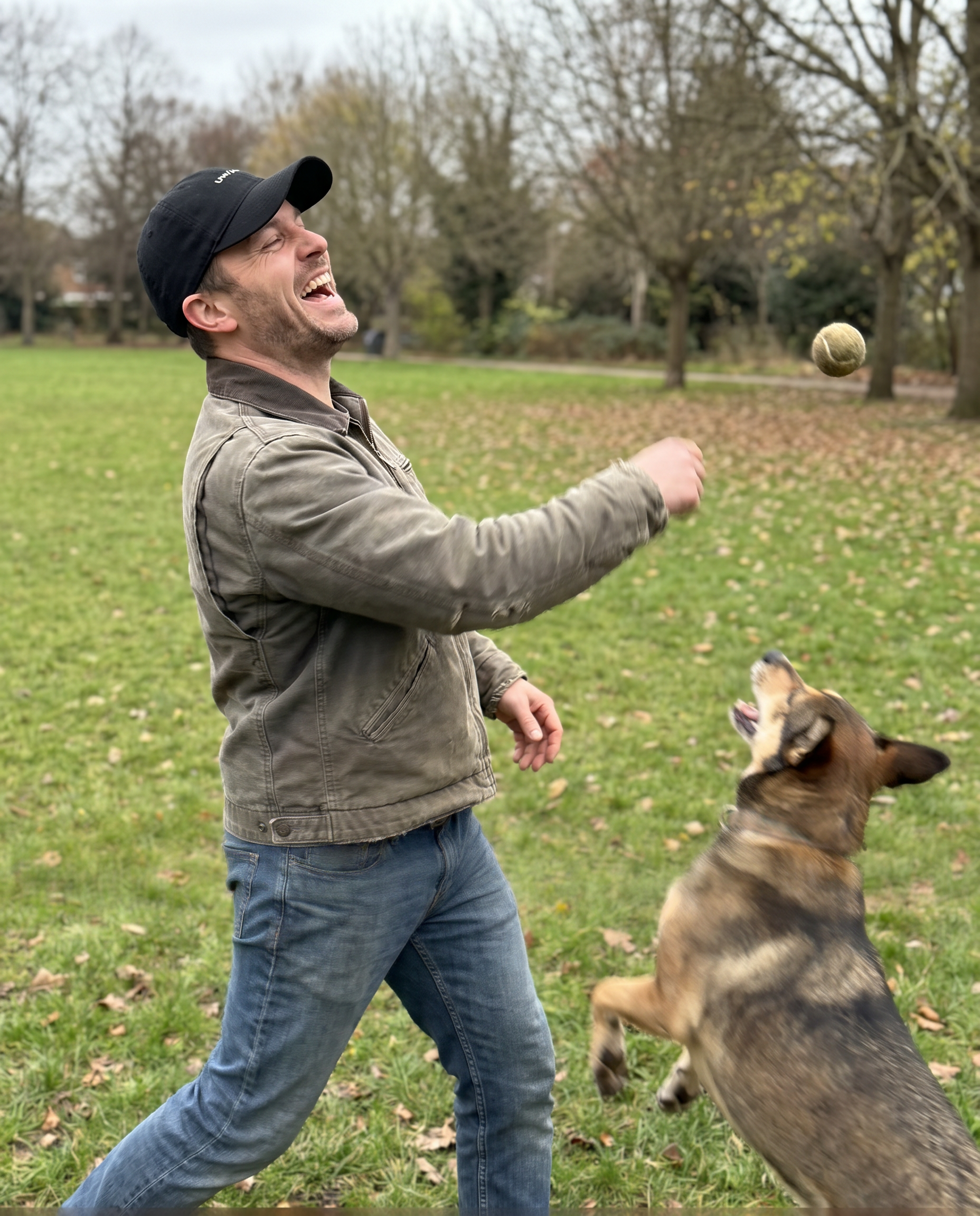 Man wearing the Halo Cap outdoors, genuine candid laugh, mid-motion