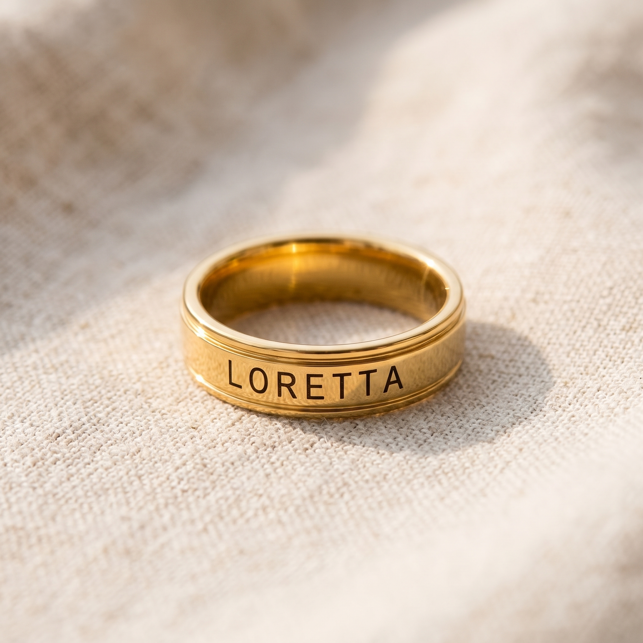 Two plain wedding bands resting on pale linen, one turned to show its inner surface