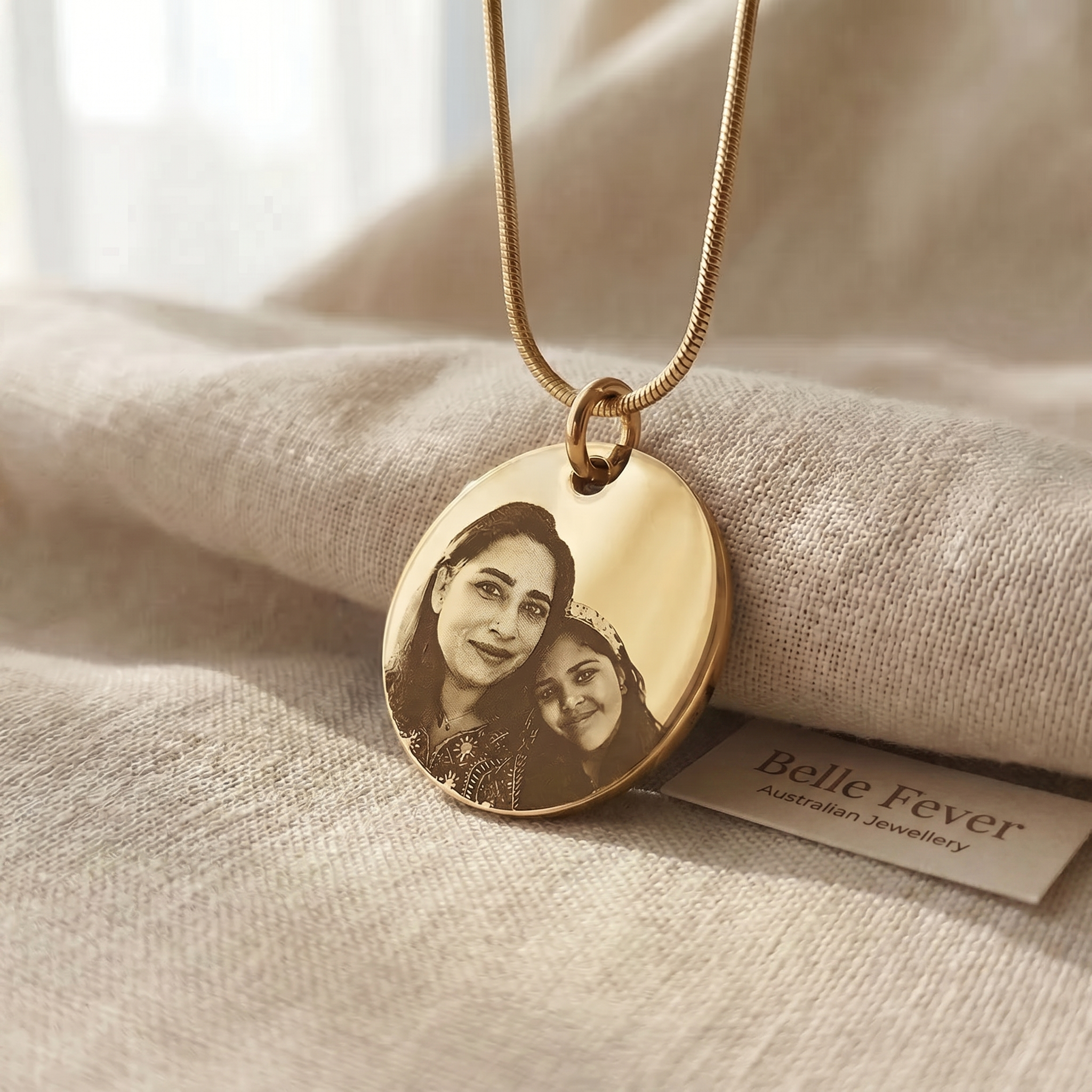 A worn engraved pendant resting on a folded linen cloth