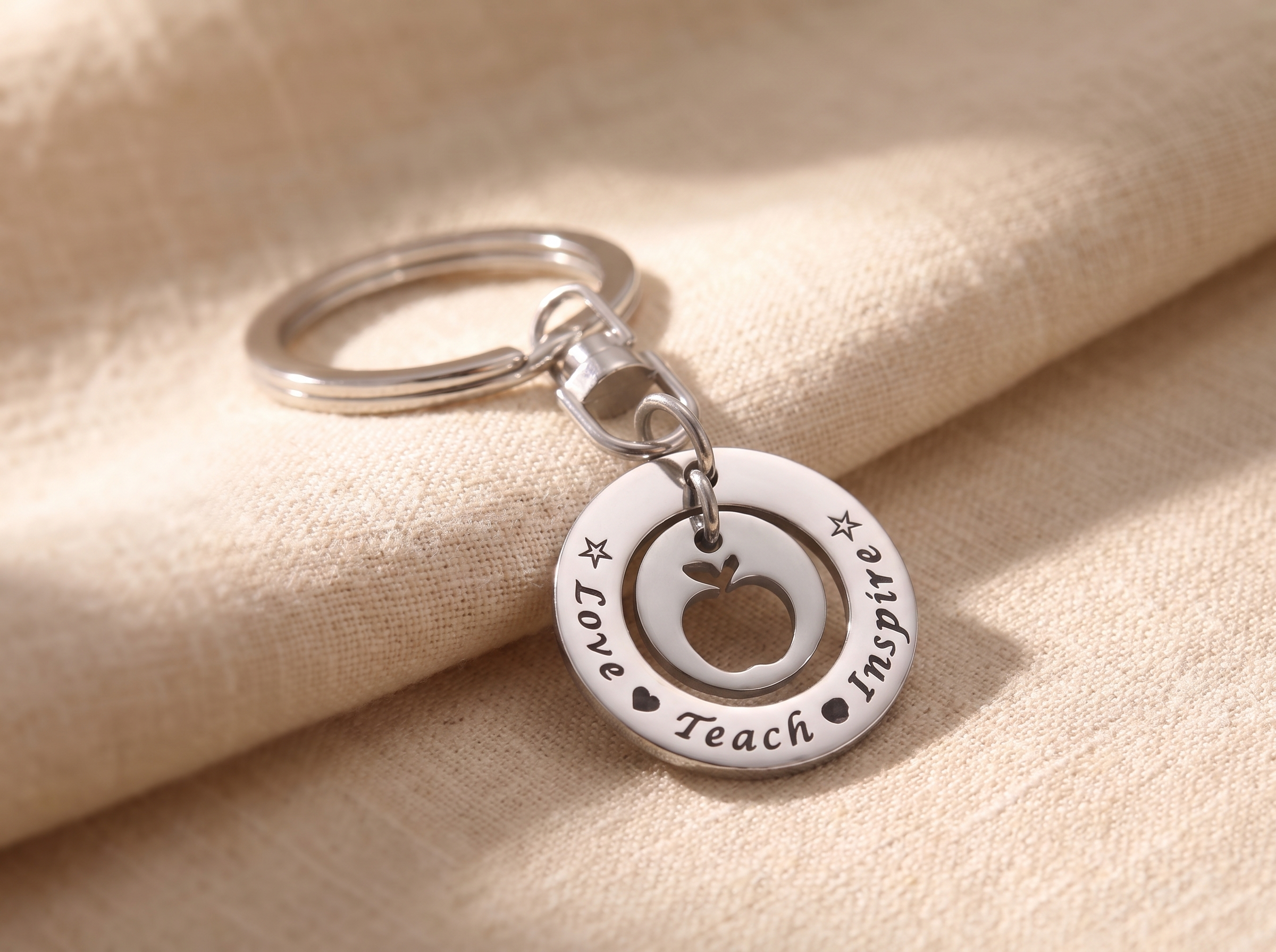 Engraved personalised teacher keyring on a lanyard resting on a classroom desk